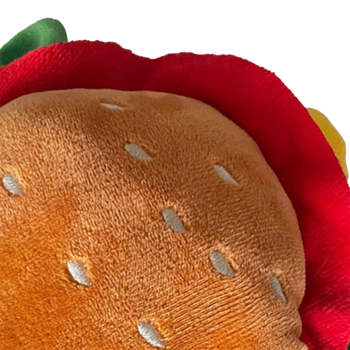 Nahaufnahme eines Spielzeug-Hamburgers. Er hat Sesamkörner auf dem Brötchen und roten Salat.