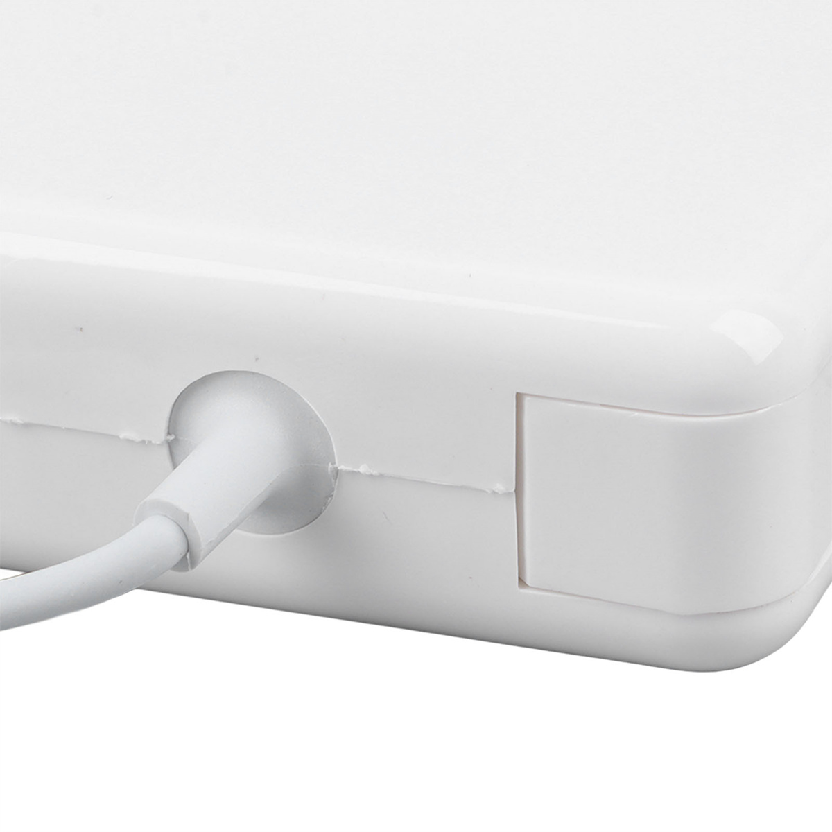 Nahaufnahme eines weißen Netzadapters mit angeschlossenem weißen Kabel.