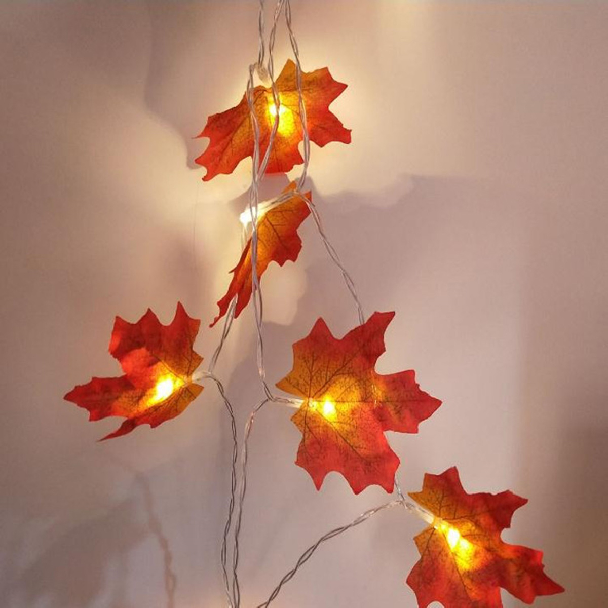 Lichterkette mit orangefarbenen Blattformen. Lichter sind an und leuchten.