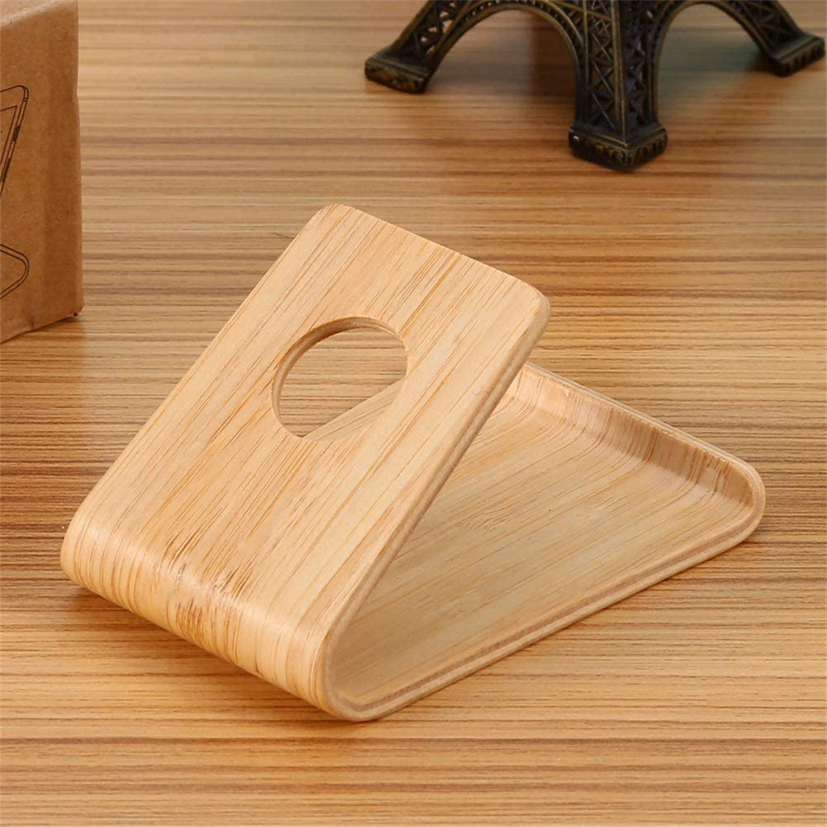 Telefonständer aus Holz. Gebogenes Design. Freiraum für das Telefon. Holzuntergrund.