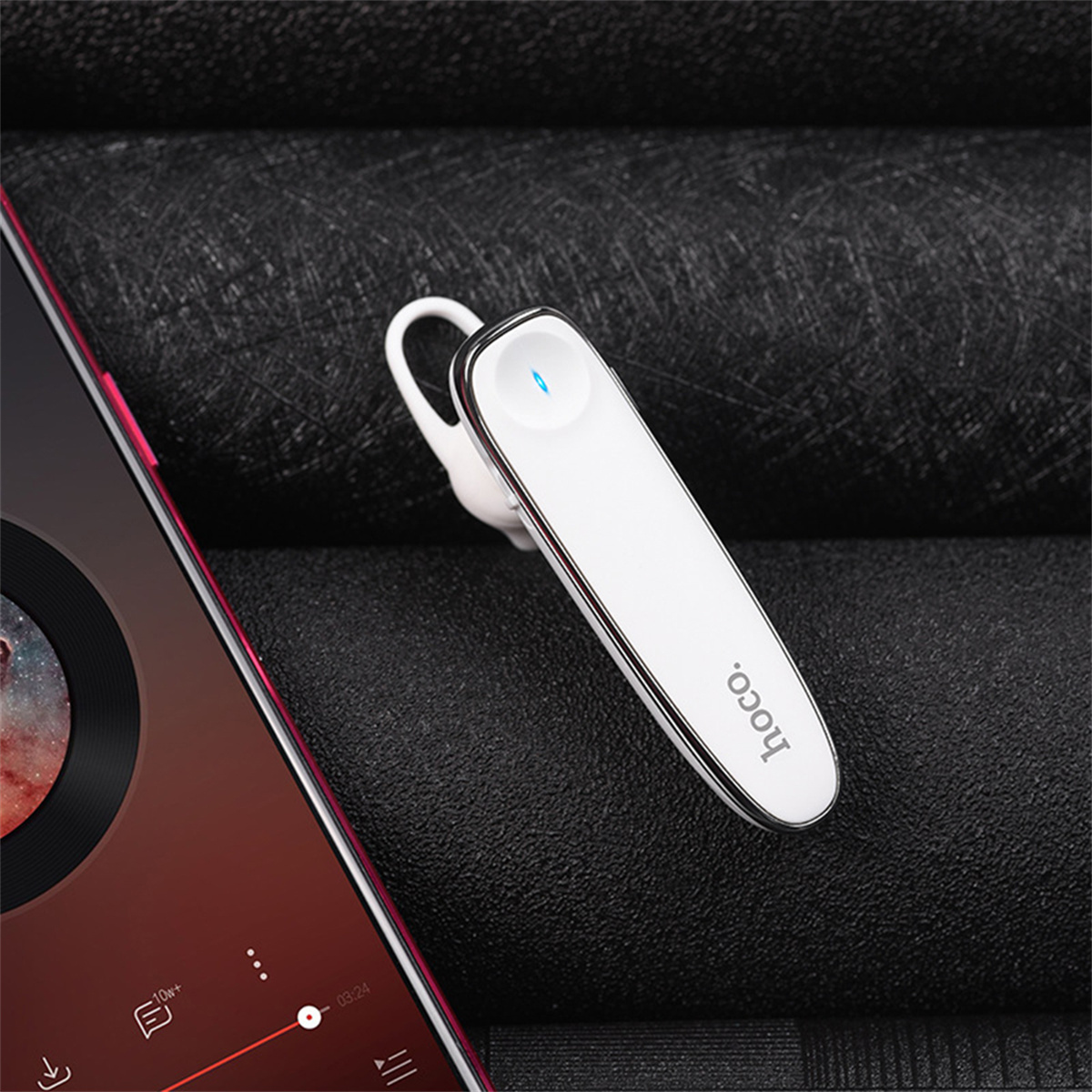 Weißes und silbernes Bluetooth-Headset auf einem Telefonbildschirm, mit schwarzem Hintergrund.