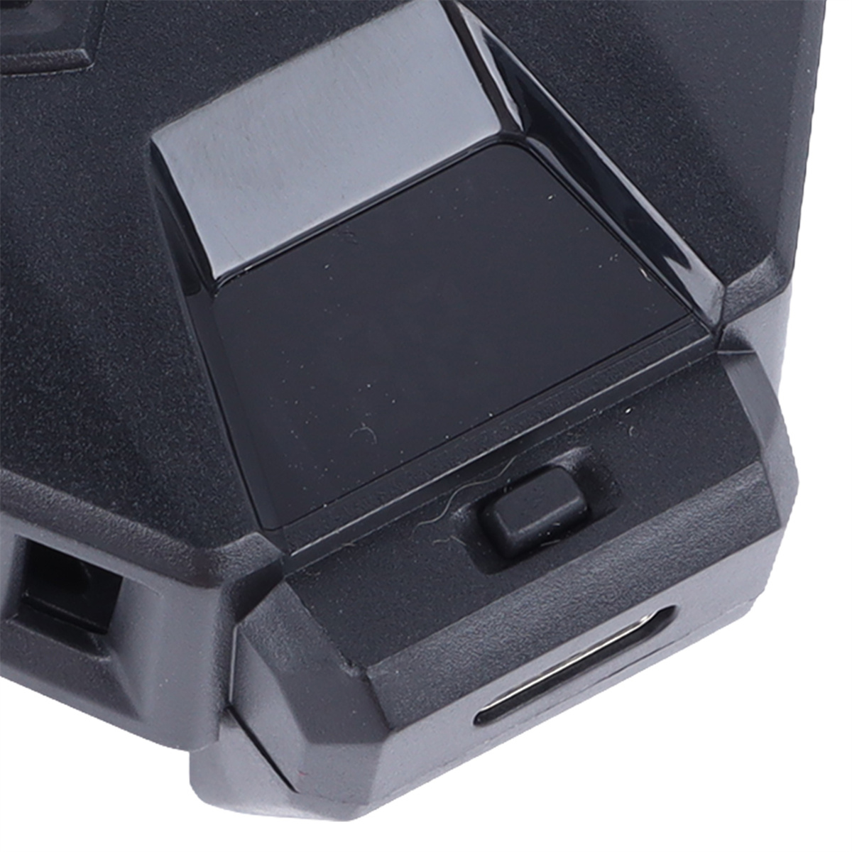 Nahaufnahme eines schwarzen, abgewinkelten Geräts mit kleinem Knopf und USB-Anschluss an der Seite.