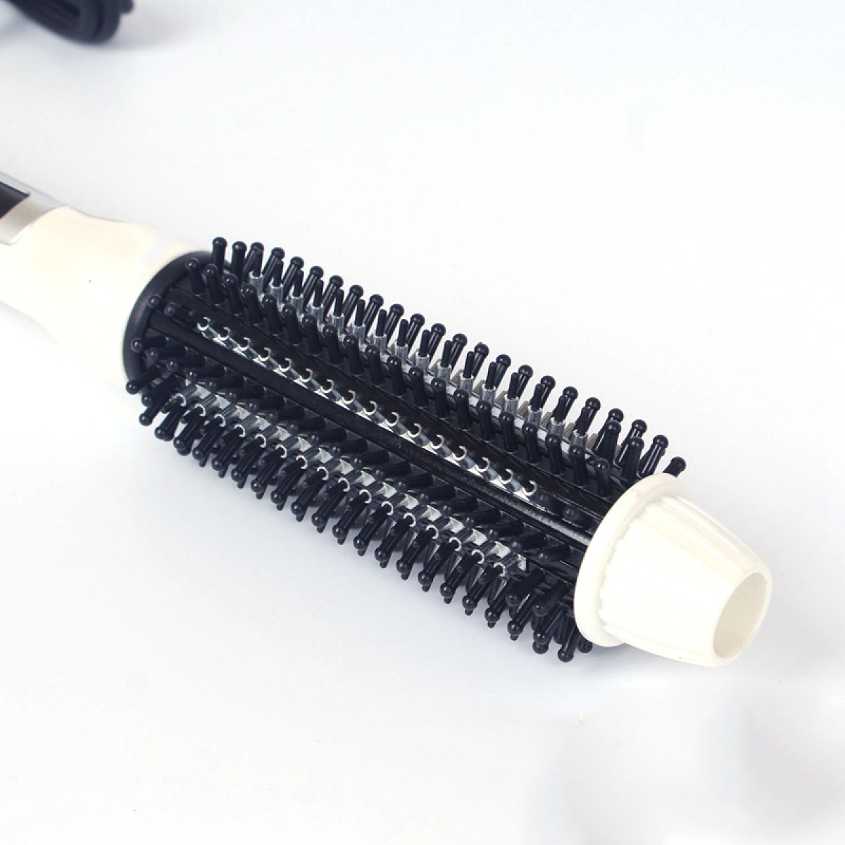 Eine weiß-schwarze Haarstylingbürste. Die Bürste ist zylindrisch mit schwarzen Borsten.