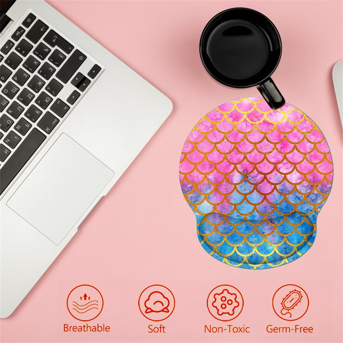 Rosa Schreibtisch mit Laptop, Mauspad und schwarzem Becher. Mauspad hat ein Meerjungfrau-Schuppen-Design.