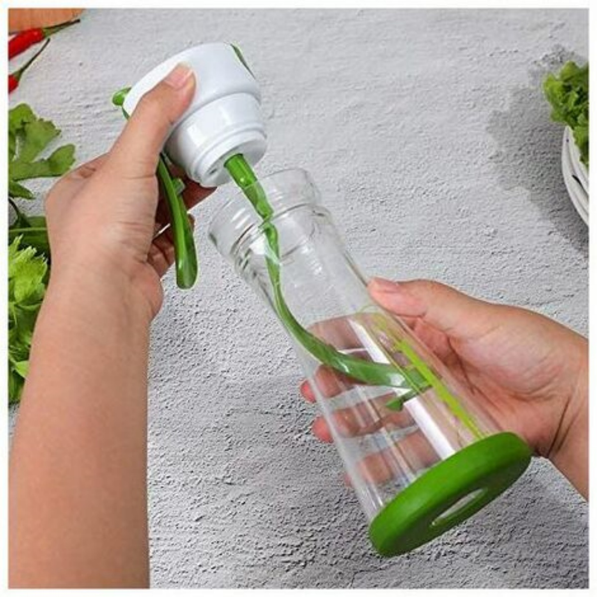 Hände setzen einen Salatdressing-Maker zusammen. Es ist grün und klar, mit Kräutern im Inneren. Heller Hintergrund.