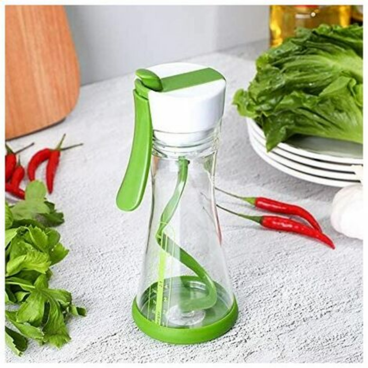 Ein klarer Salatdressing-Mixer mit grünen Akzenten, gefüllt mit Flüssigkeit und einem Mischmechanismus.