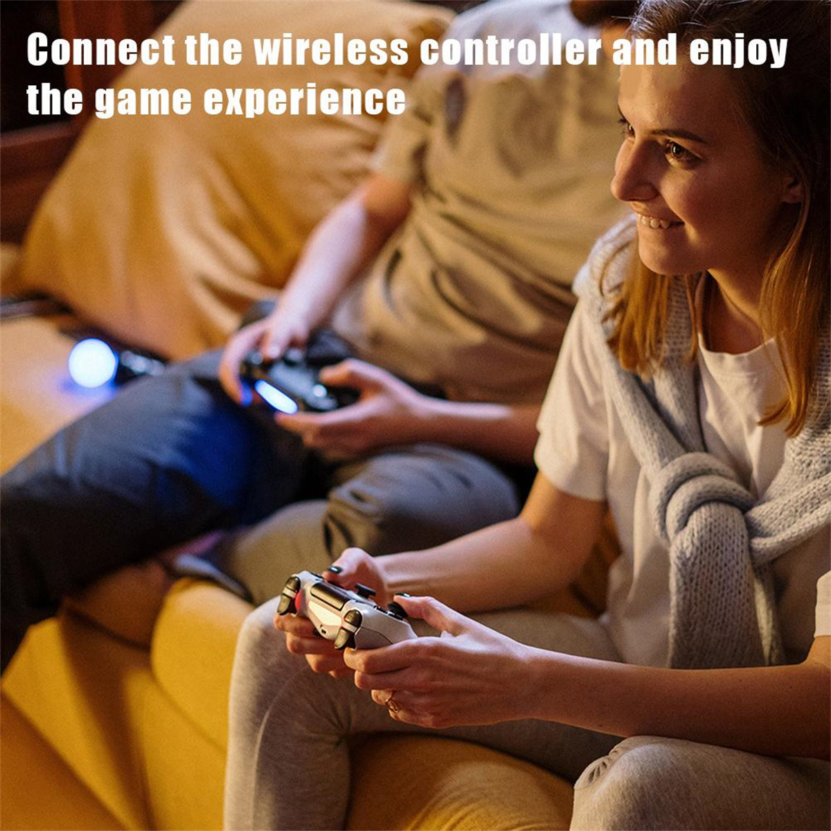 Zwei Personen spielen Videospiele. Einer hält einen weißen Controller und lächelt.