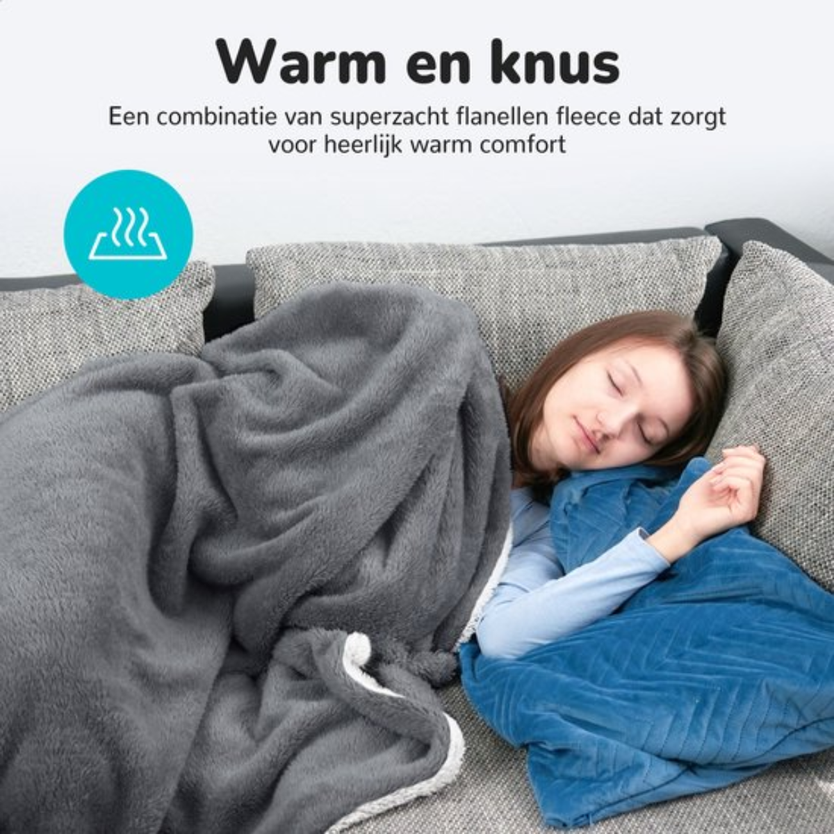 A woman sleeping under a gray blanket and a blue pillow on a gray couch.