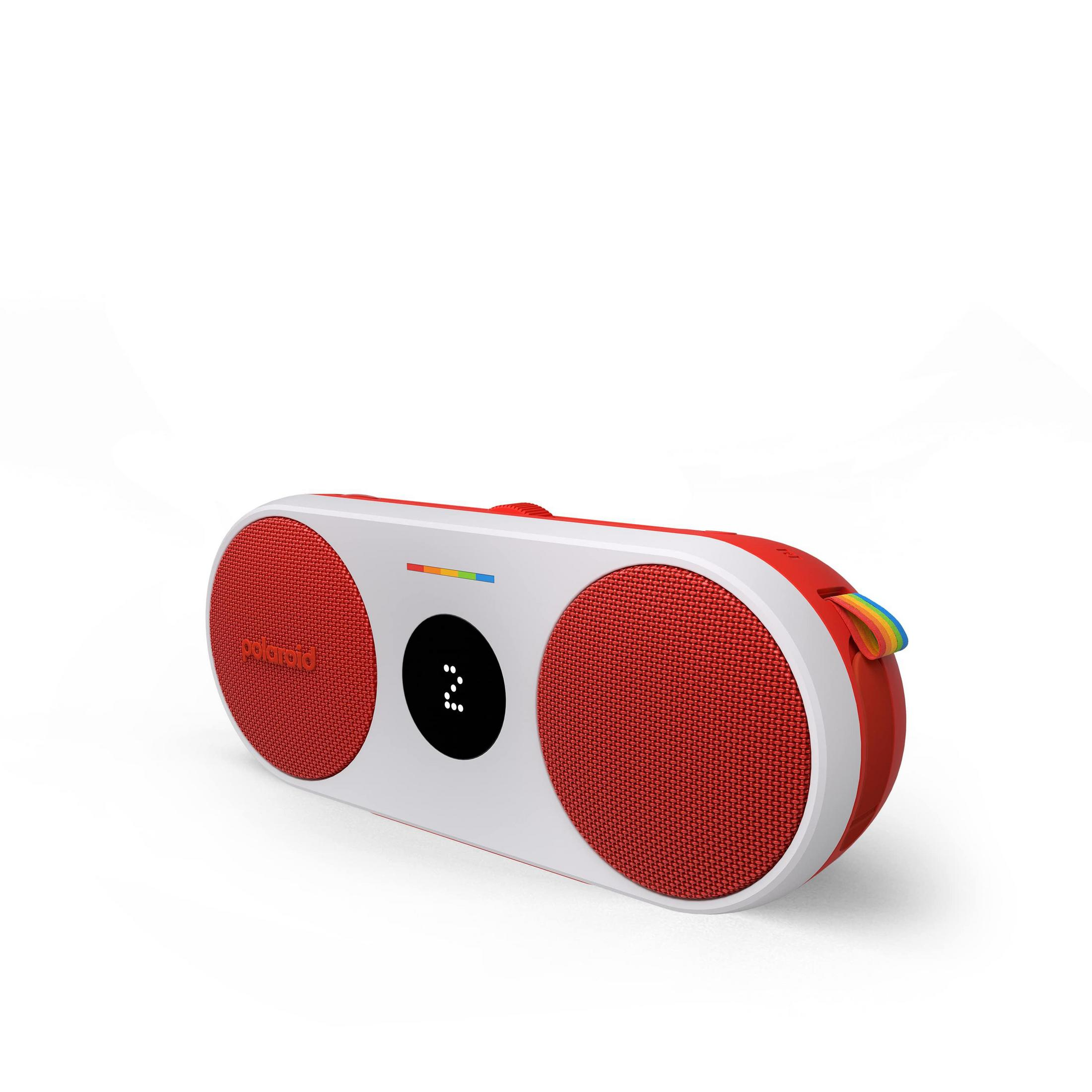 Czerwono-biały głośnik Polaroid z czerwoną maskownicą i małym wyświetlaczem.