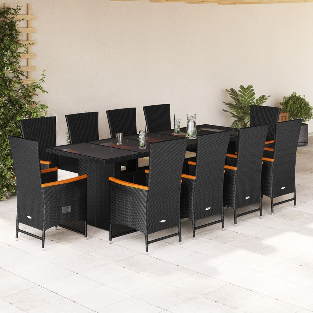 Essgruppe im Freien mit schwarzen Stühlen, einem schwarzen Tisch und Gläsern auf dem Tisch.