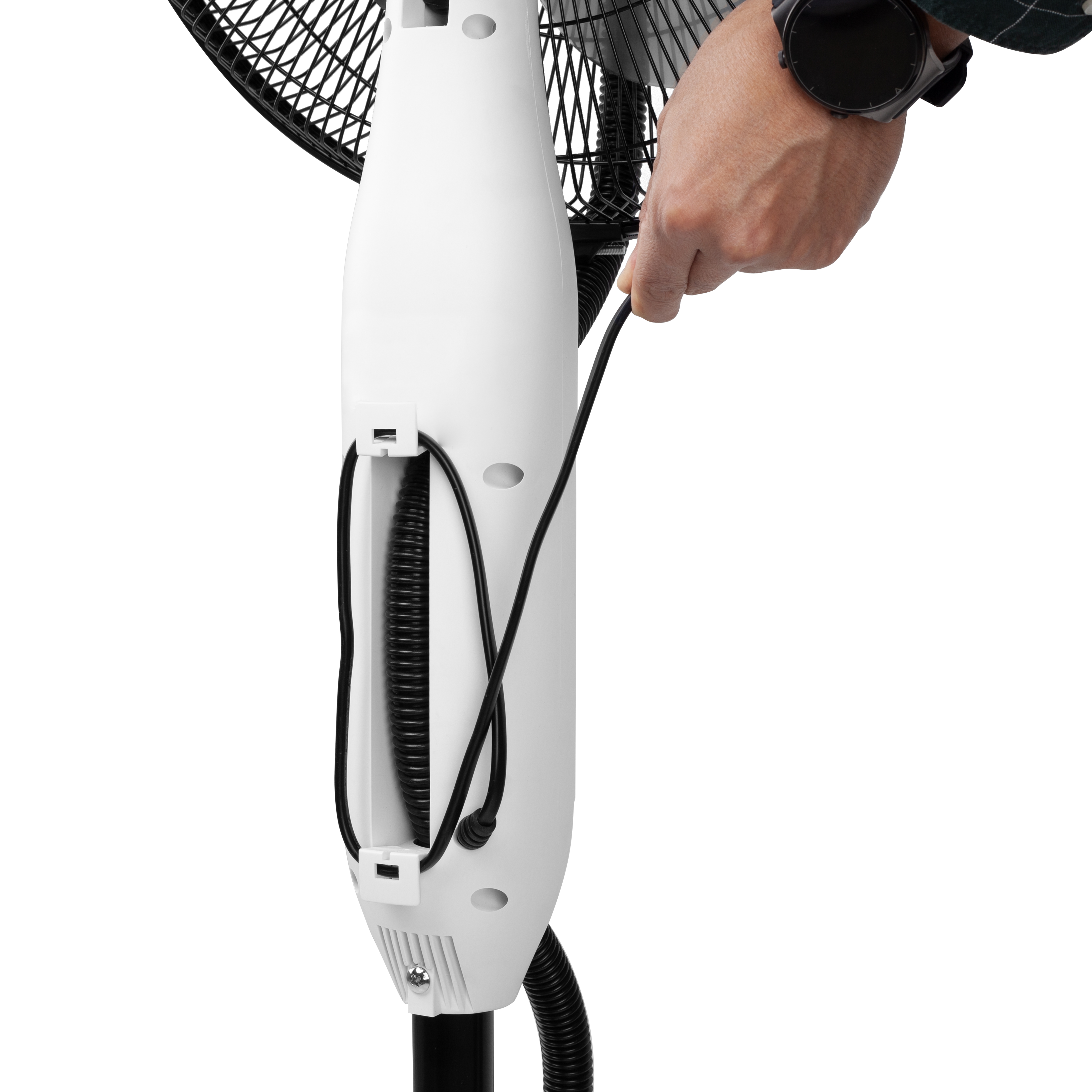 La mano de una persona está conectando un cable de alimentación negro a una base de ventilador blanca.