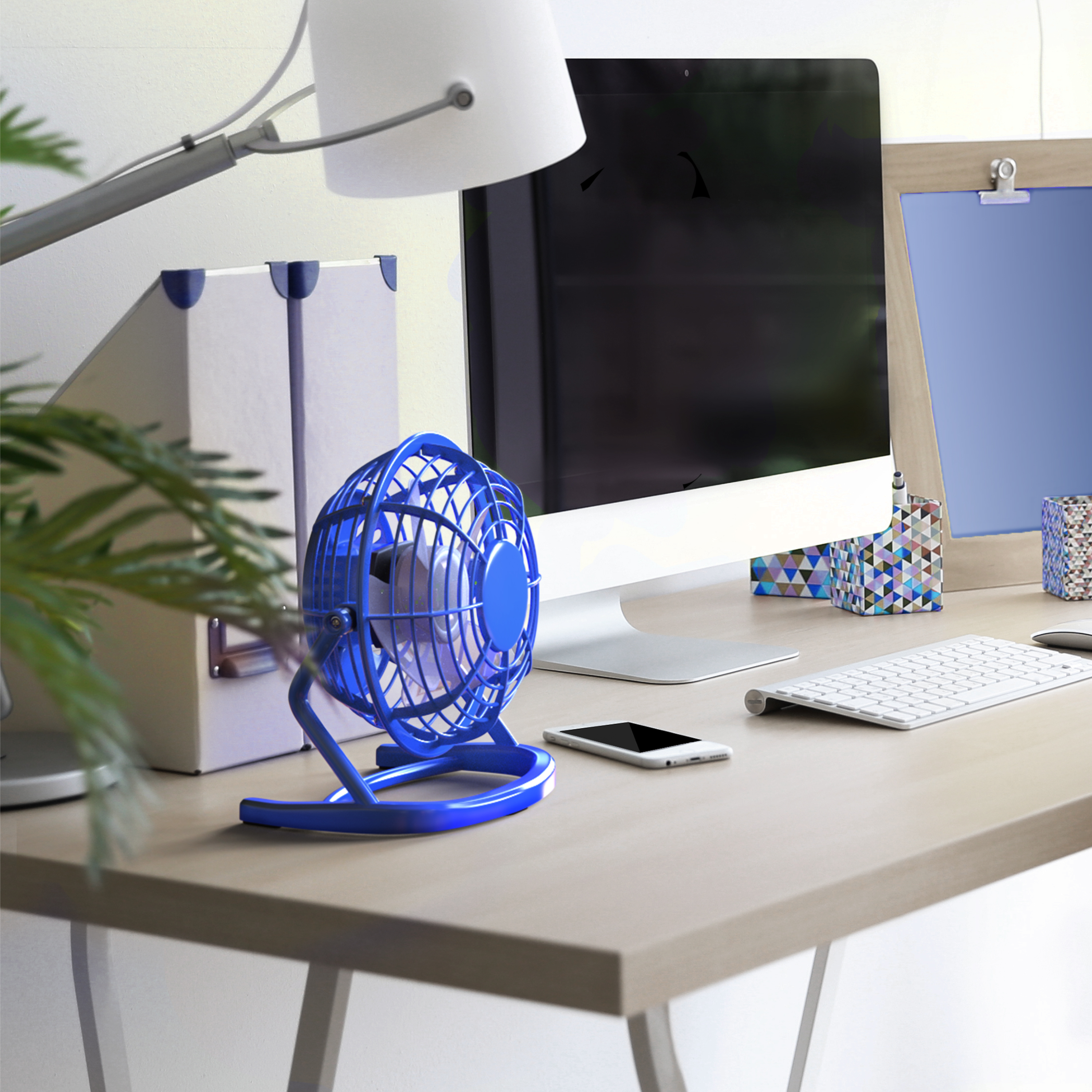 Blauer Schreibtischventilator auf einem Holzschreibtisch mit Computer, Lampe und Büromaterial. Tageslicht.