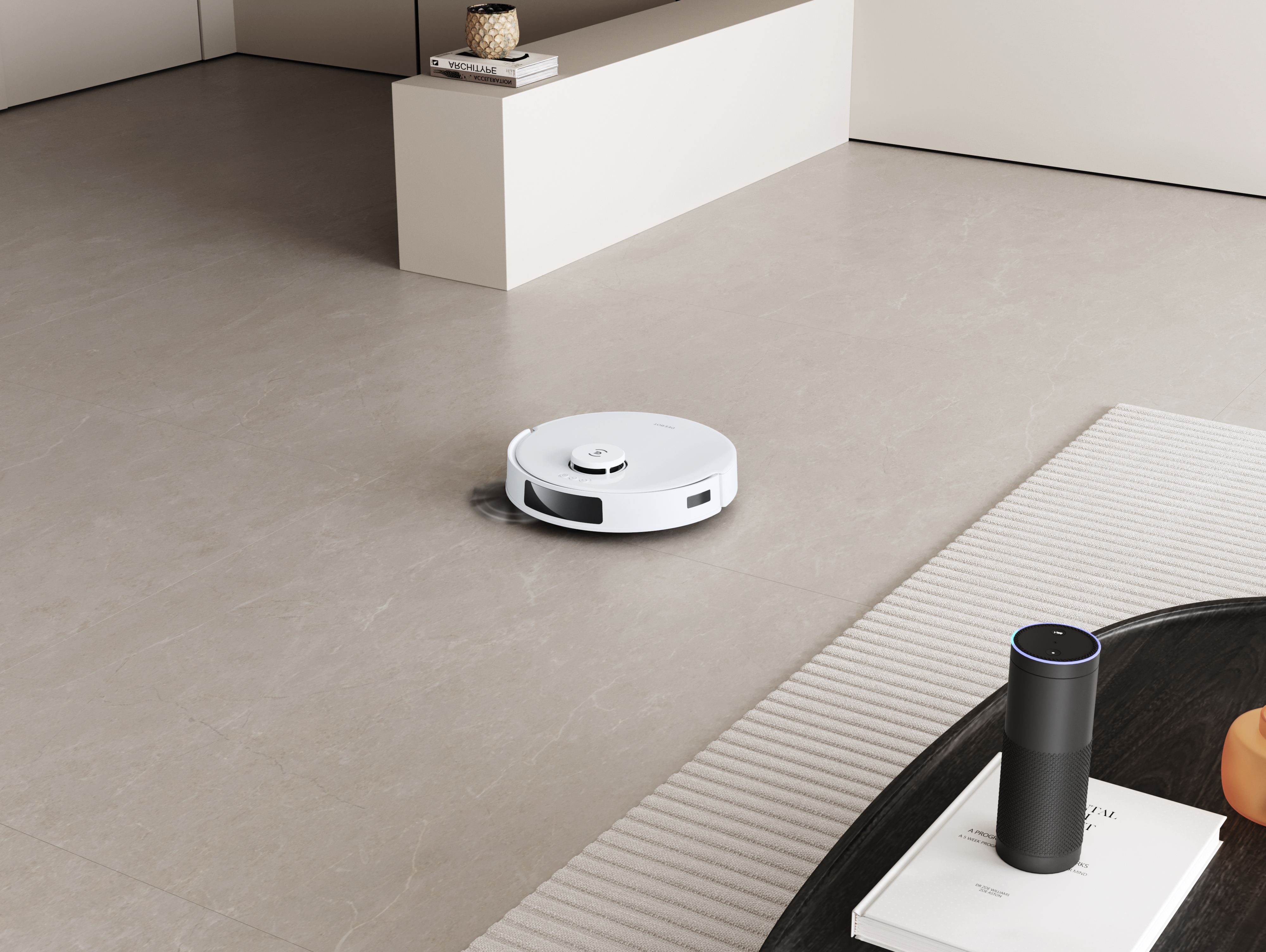 Biały odkurzacz robot na jasnoszarej podłodze z płytek, w pobliżu czarnego głośnika i stolika kawowego.