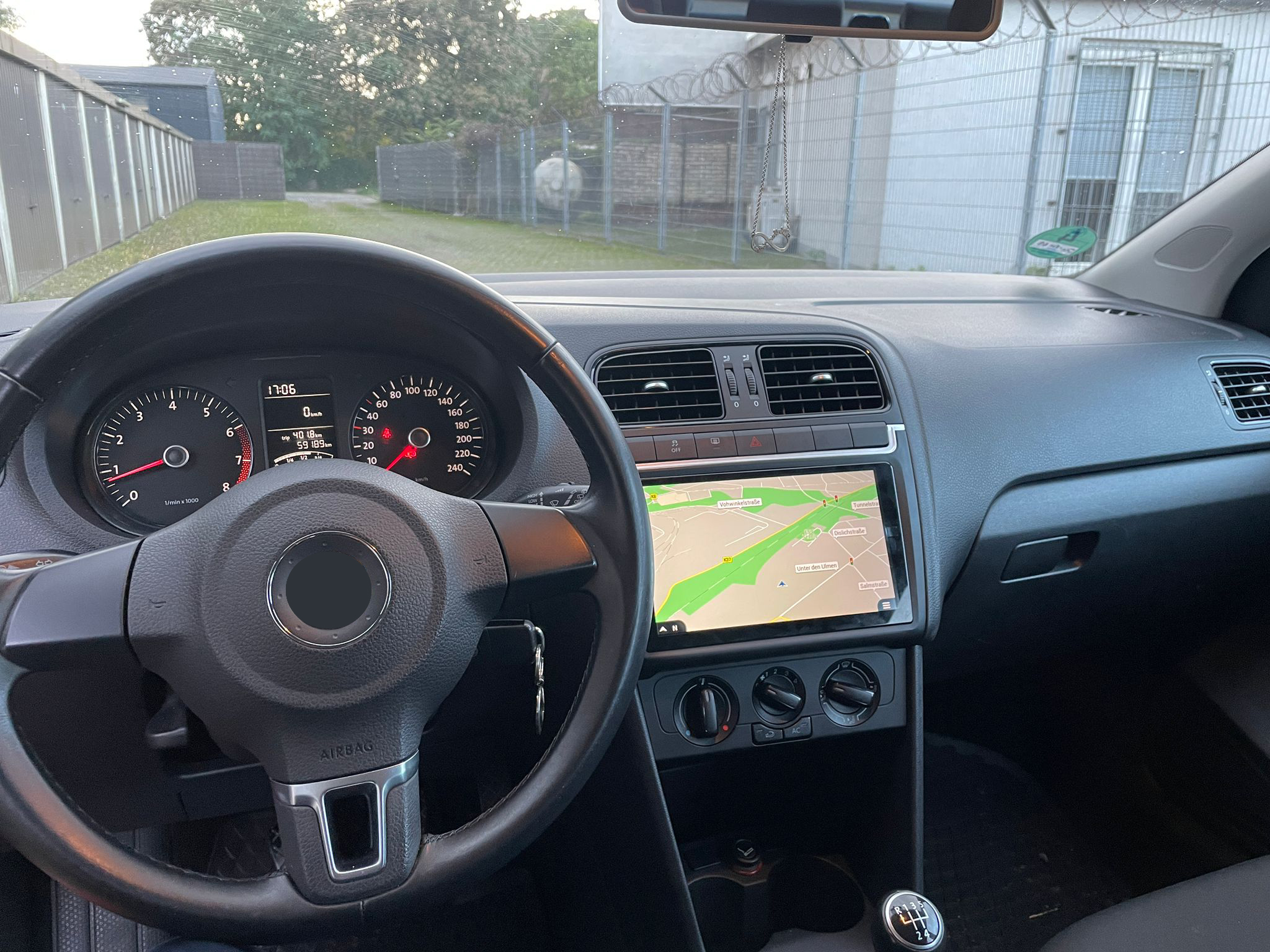 Innenraum eines Autos mit Navigationsbildschirm und sichtbarem Lenkrad.