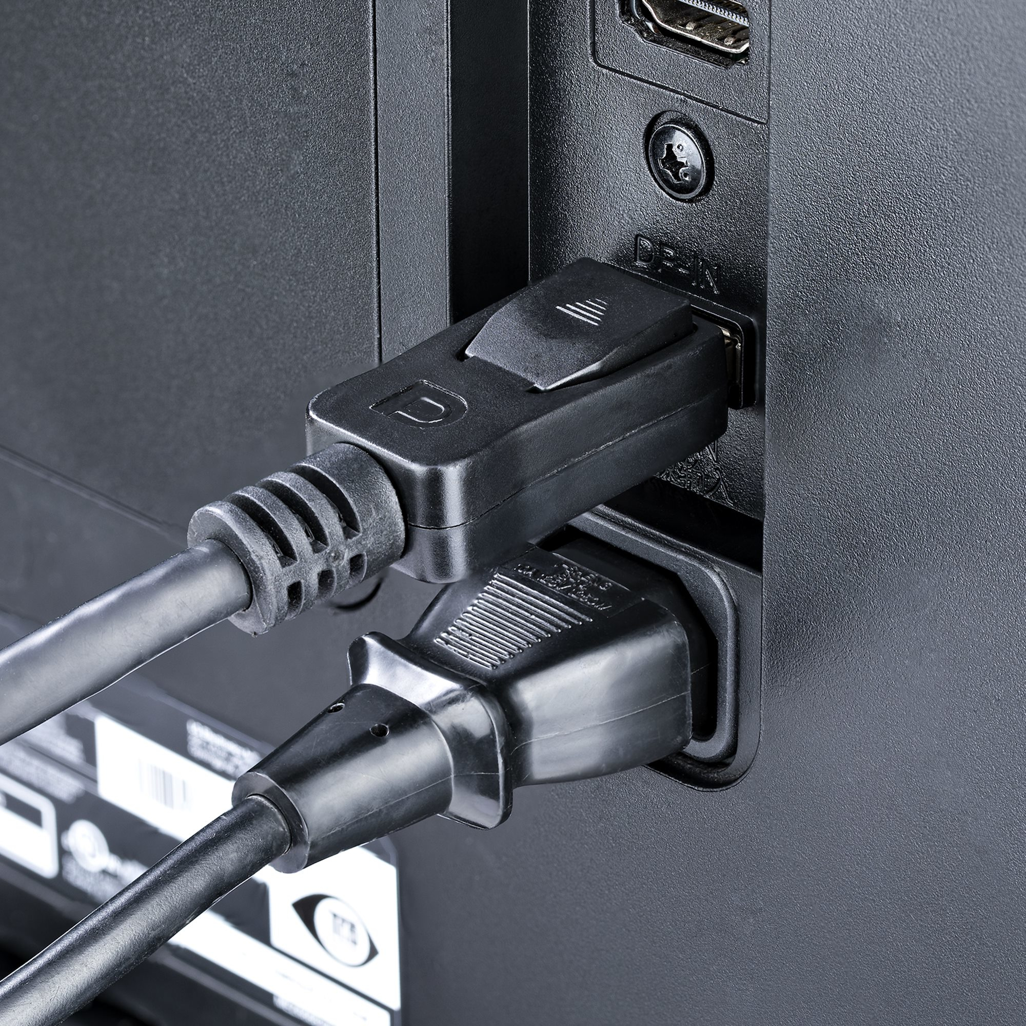 Close-up van de achterkant van een zwart apparaat met stekkers voor stroom- en displaypoortkabels.