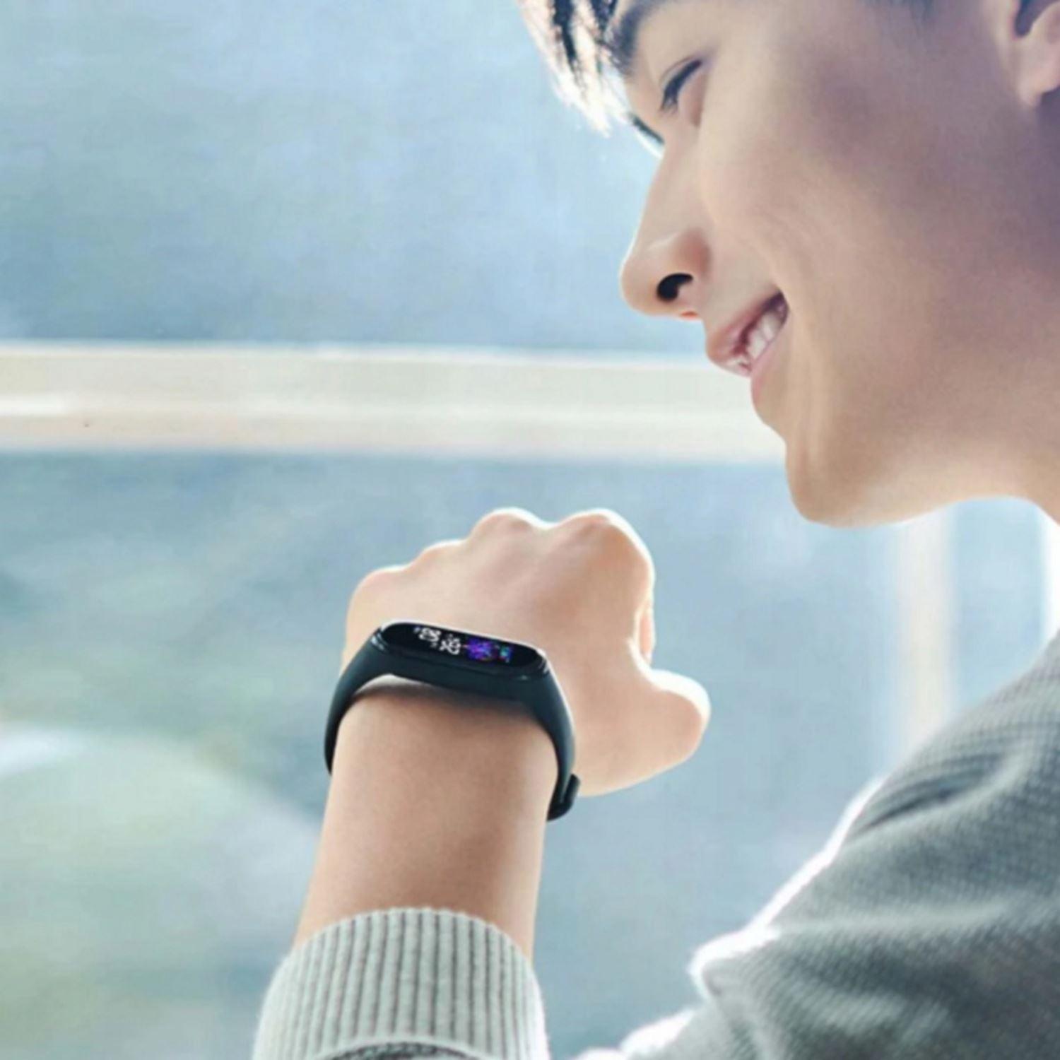 Persona sonriente con smartwatch. Fondo borroso. El reloj muestra información.