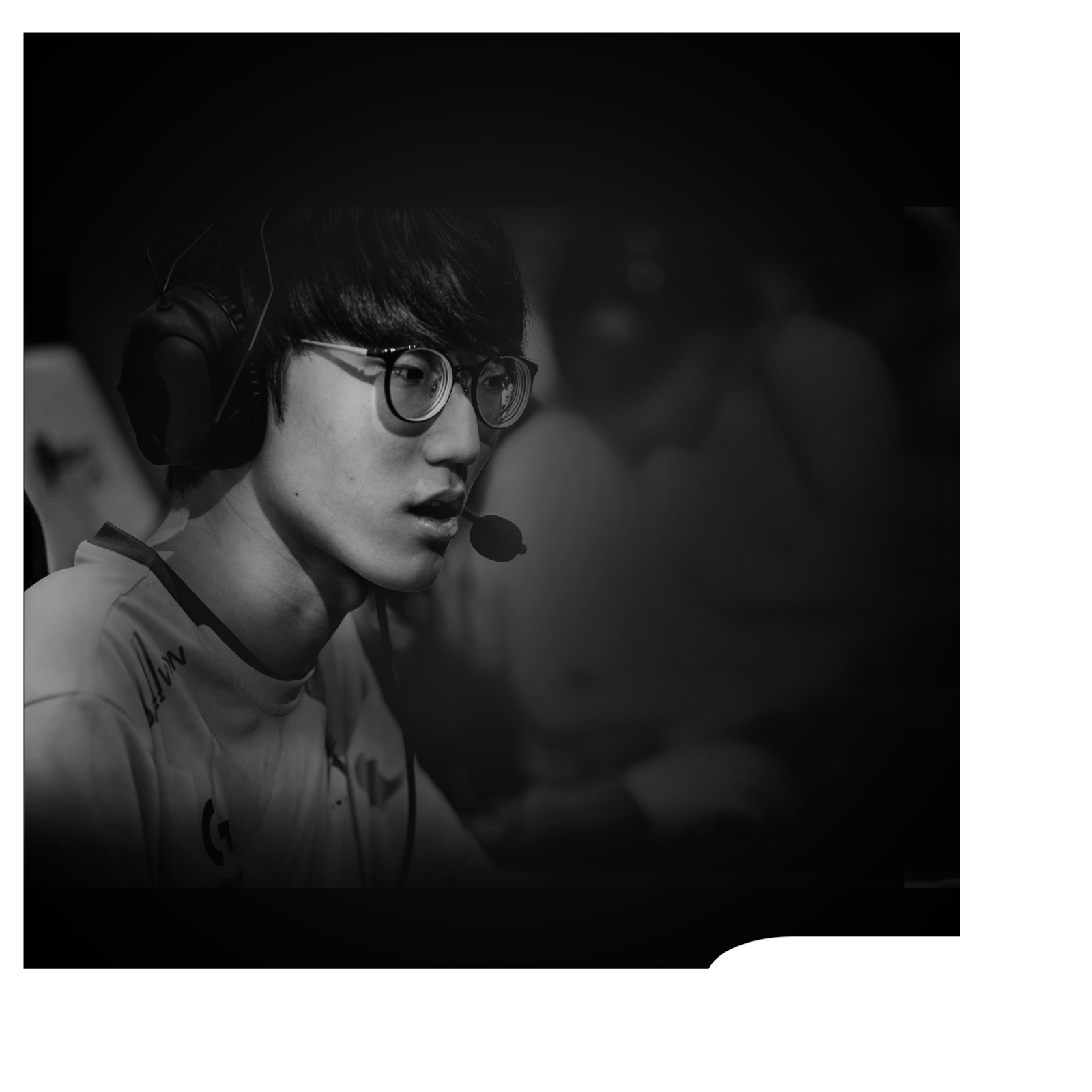 Kulaklık ve gözlük takan, ekrana odaklanmış bir oyuncunun siyah beyaz görüntüsü.