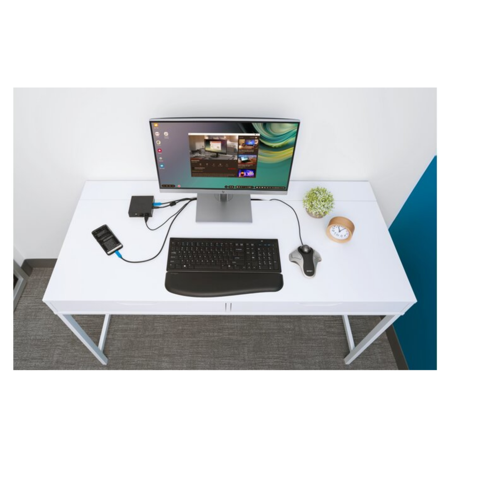 Bureau de bureau avec moniteur, clavier, souris et autres éléments technologiques.