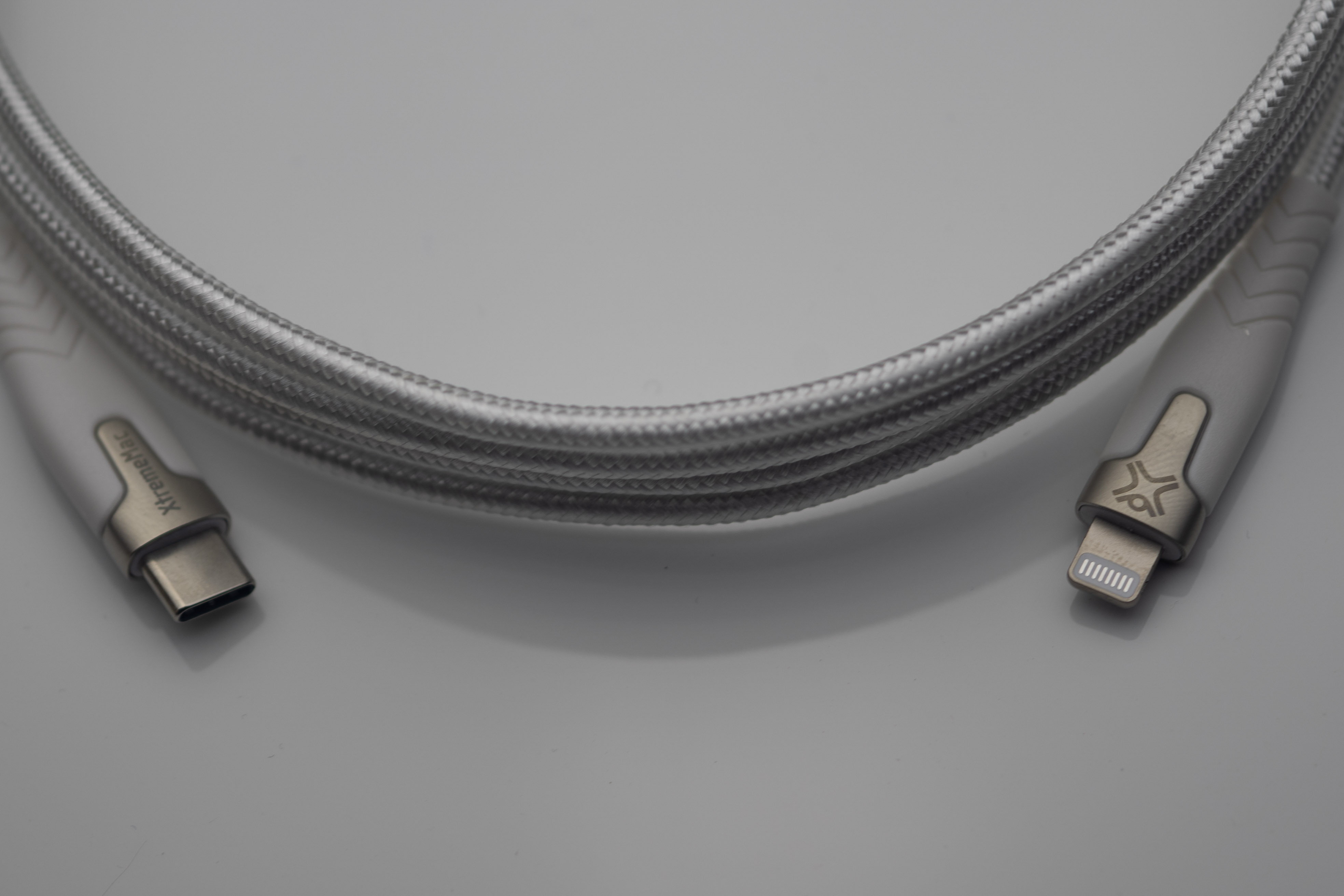 Witte USB-C naar Lightning kabel. Een grijze gevlochten kabel in een achtvorm.