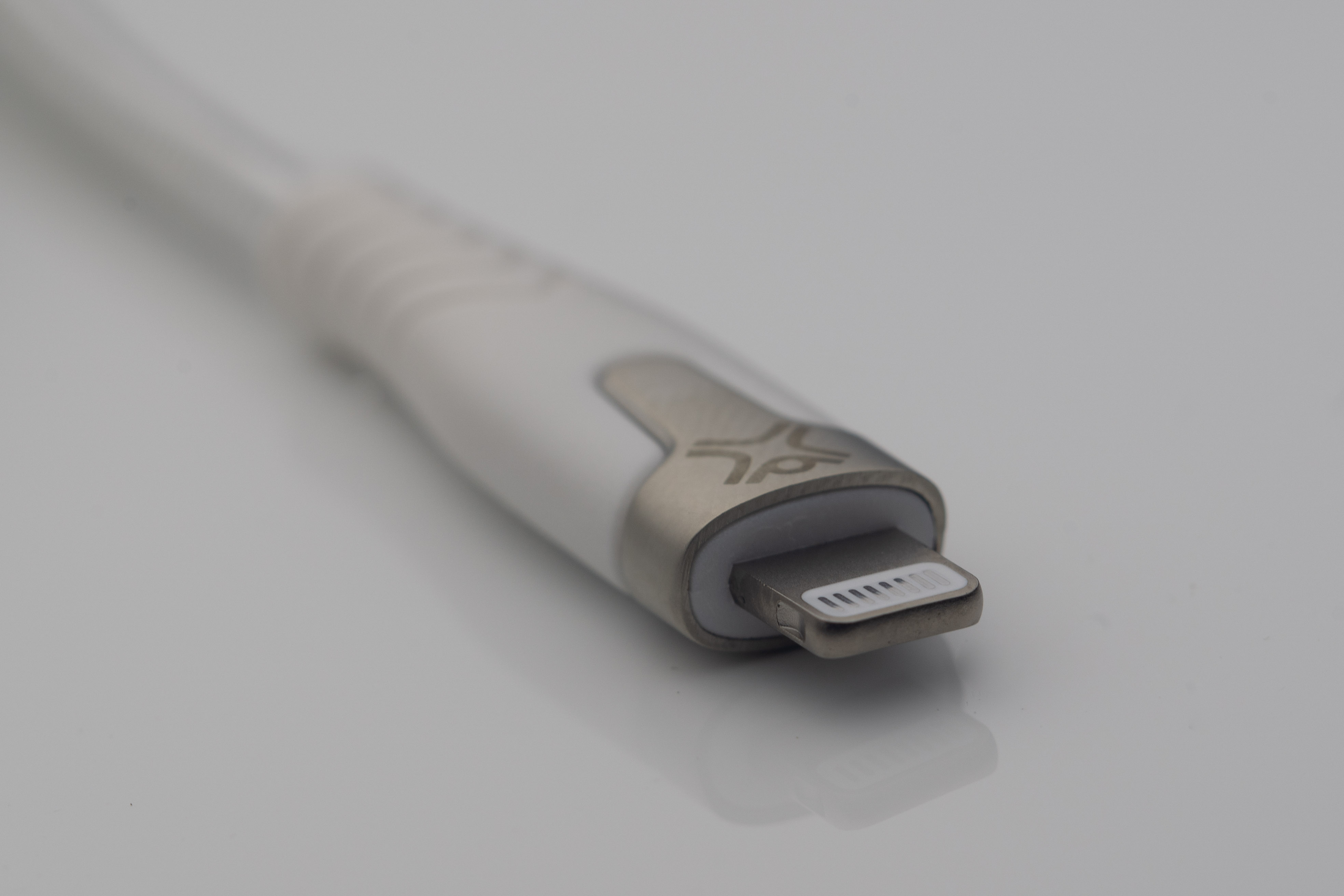 Een witte oplaadkabel met een zilveren connector.