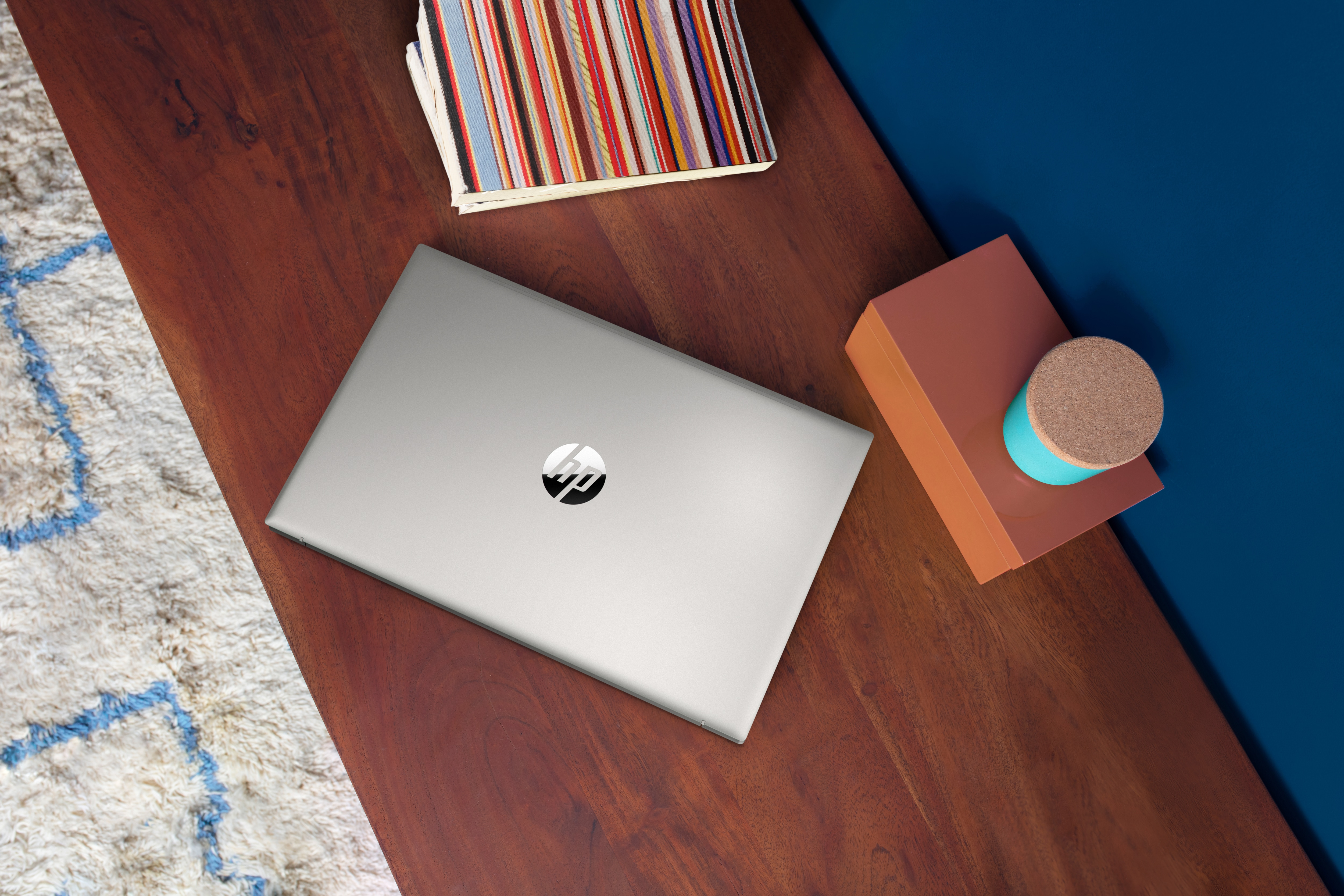 Laptop su un tavolo di legno con alcuni oggetti decorativi.