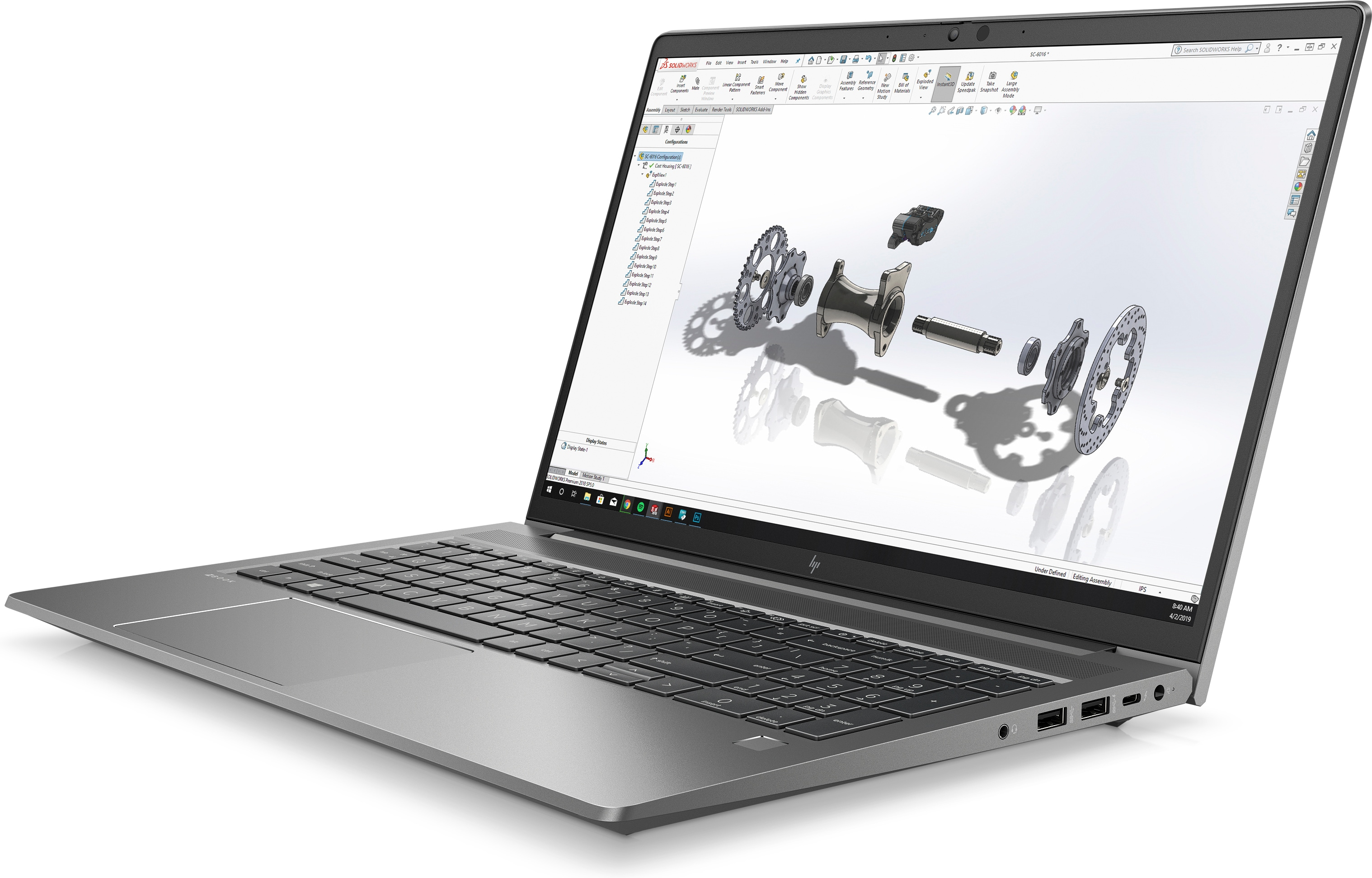 Silver laptop, open, displaying an engineering design on screen. Black keyboard, white background.