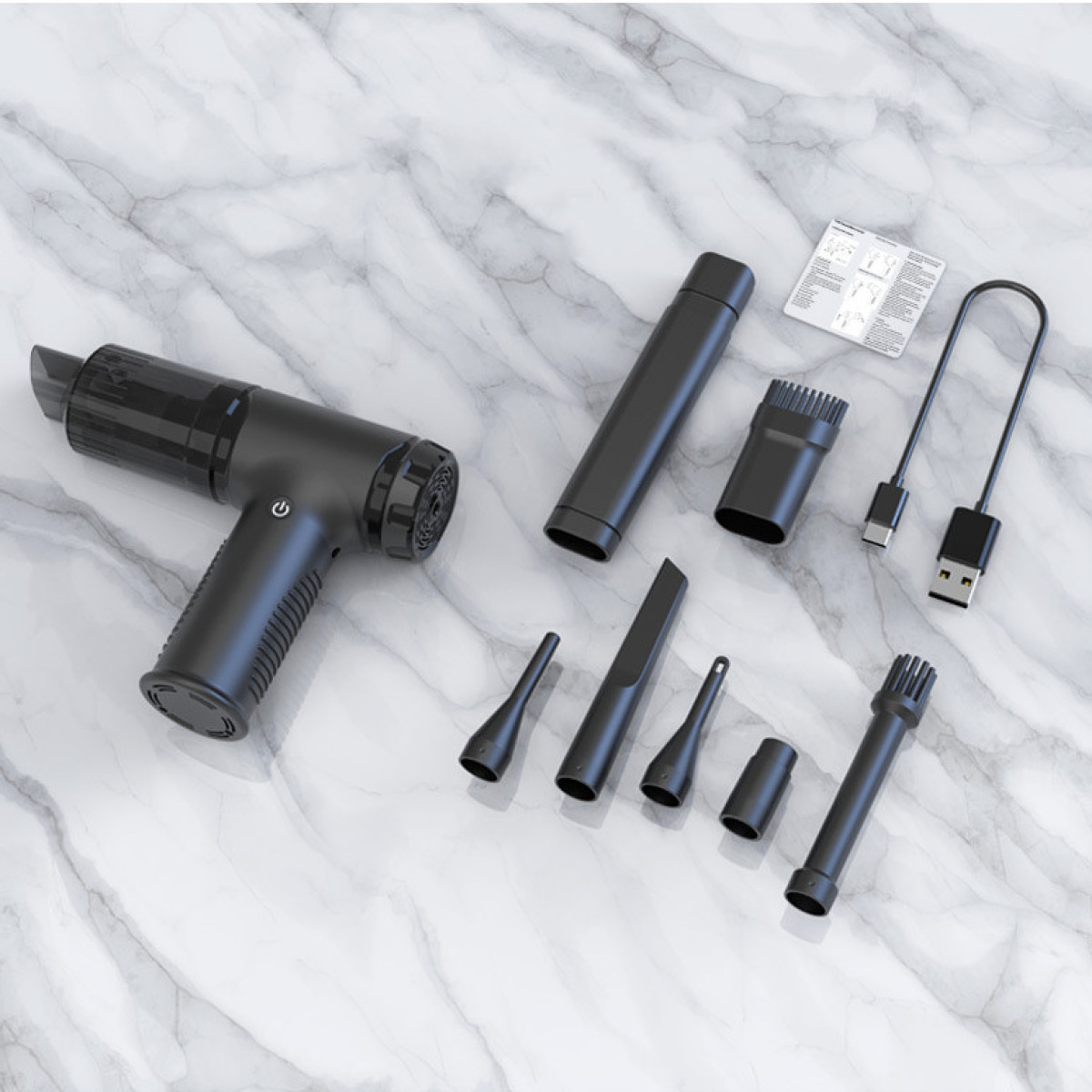 Czarny odkurzacz ręczny z akcesoriami na marmurowej powierzchni. Zawiera dysze, szczotki i akcesoria do ładowania.