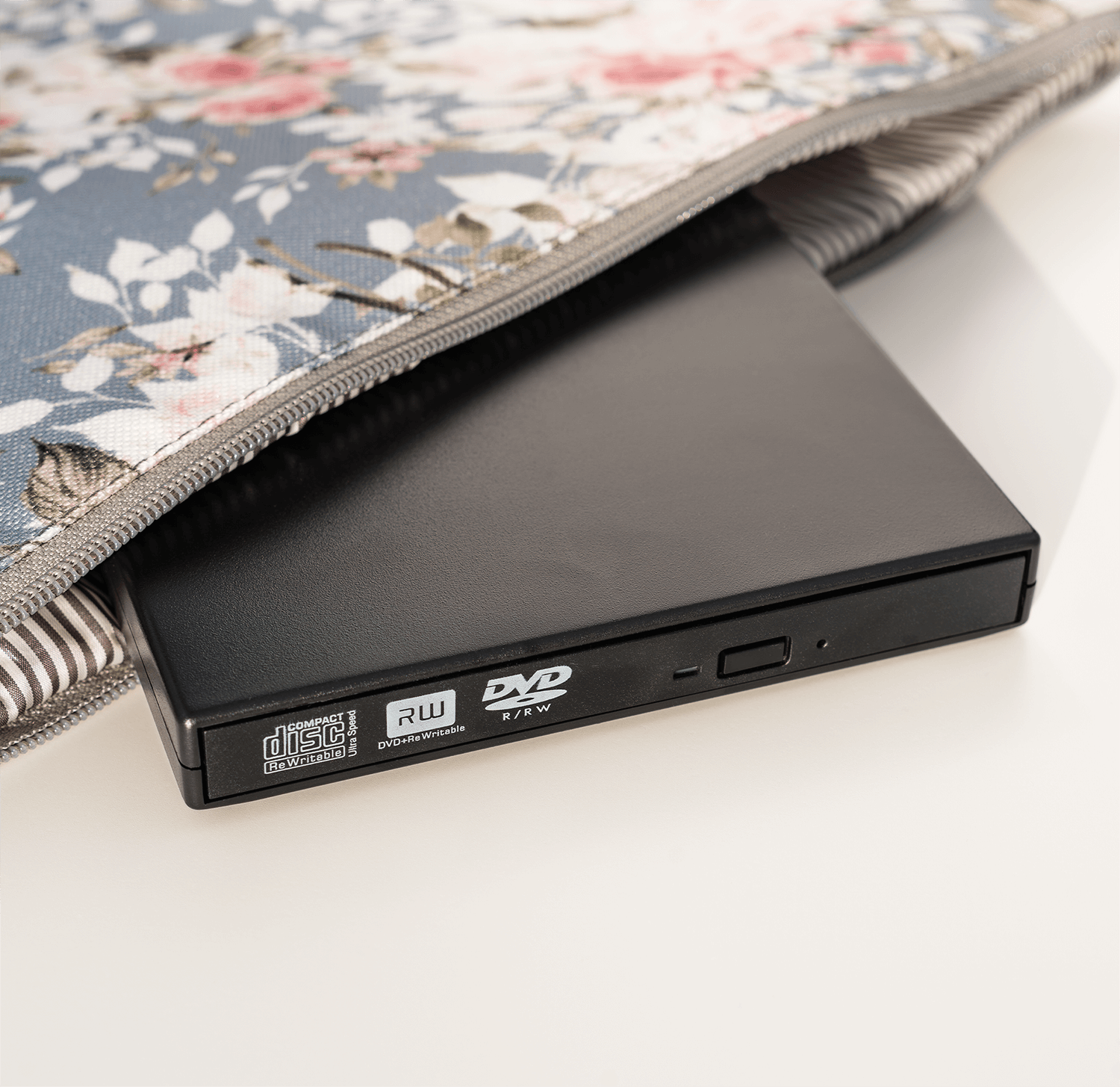 Czarny napęd DVD w torbie we wzór kwiatowy, na białym tle.