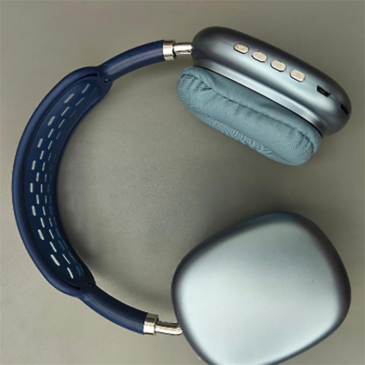 Blaue Kopfhörer mit Ohrmuscheln auf einer grauen Oberfläche. Das Kopfband ist ebenfalls blau.