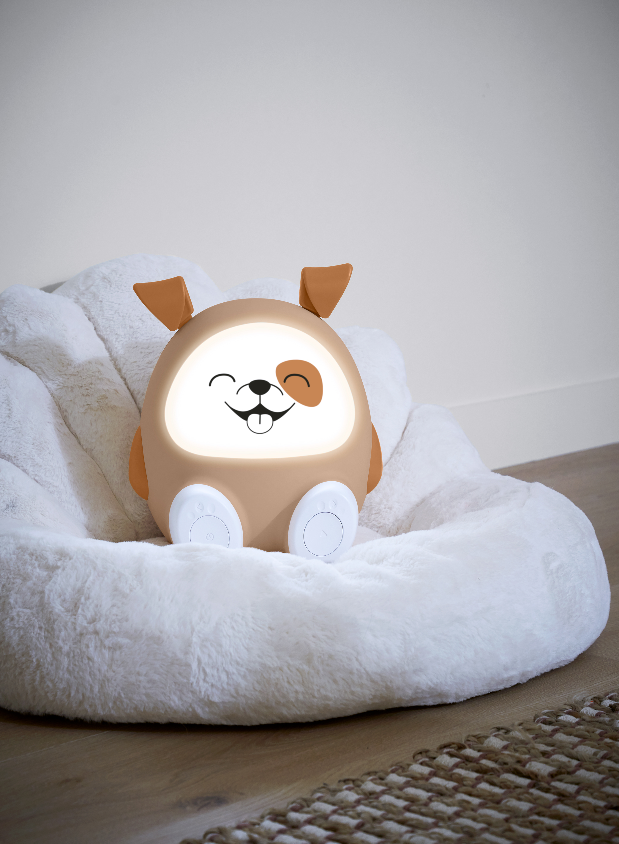 Veilleuse en forme de chien sur un lit moelleux. Couleur marron et blanc.