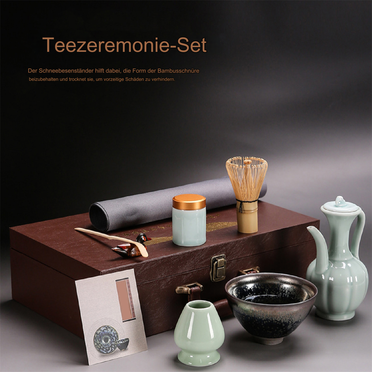Ein Teezeremonie-Set mit Holzkiste, Werkzeugen und einer Matcha-Schale auf dunklem Hintergrund.
