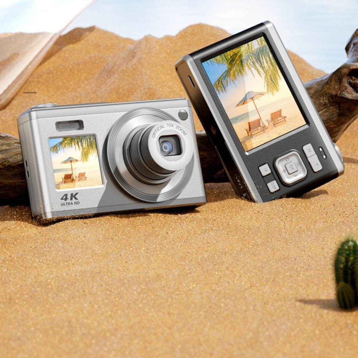 Zwei Kameras auf Sand. Eine silberne, eine schwarze. Die Bildschirme zeigen Strandszenen. Kaktus im Hintergrund.