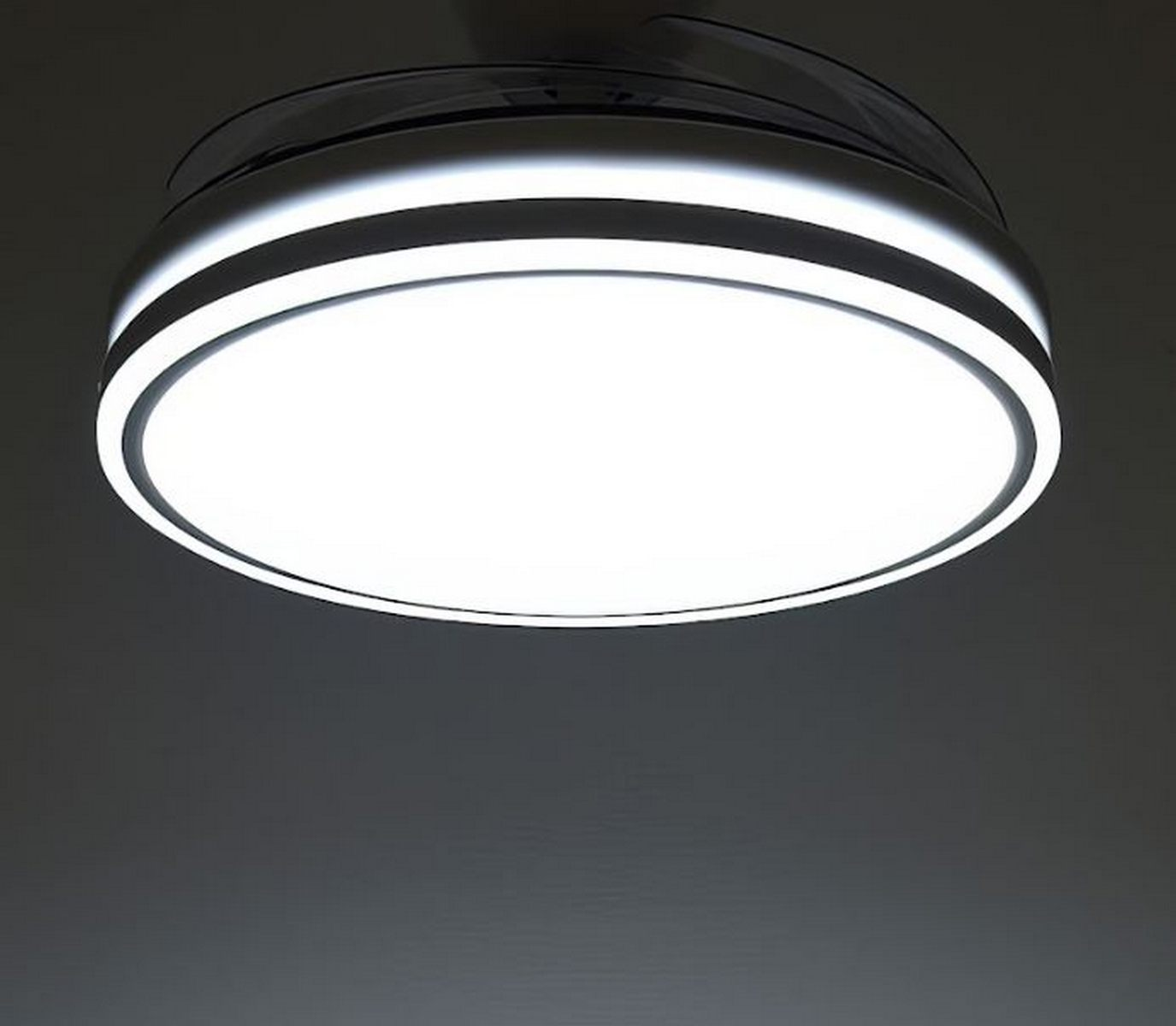 Luz de techo, diseño circular blanco y negro, ilumina la habitación. Techo gris oscuro.