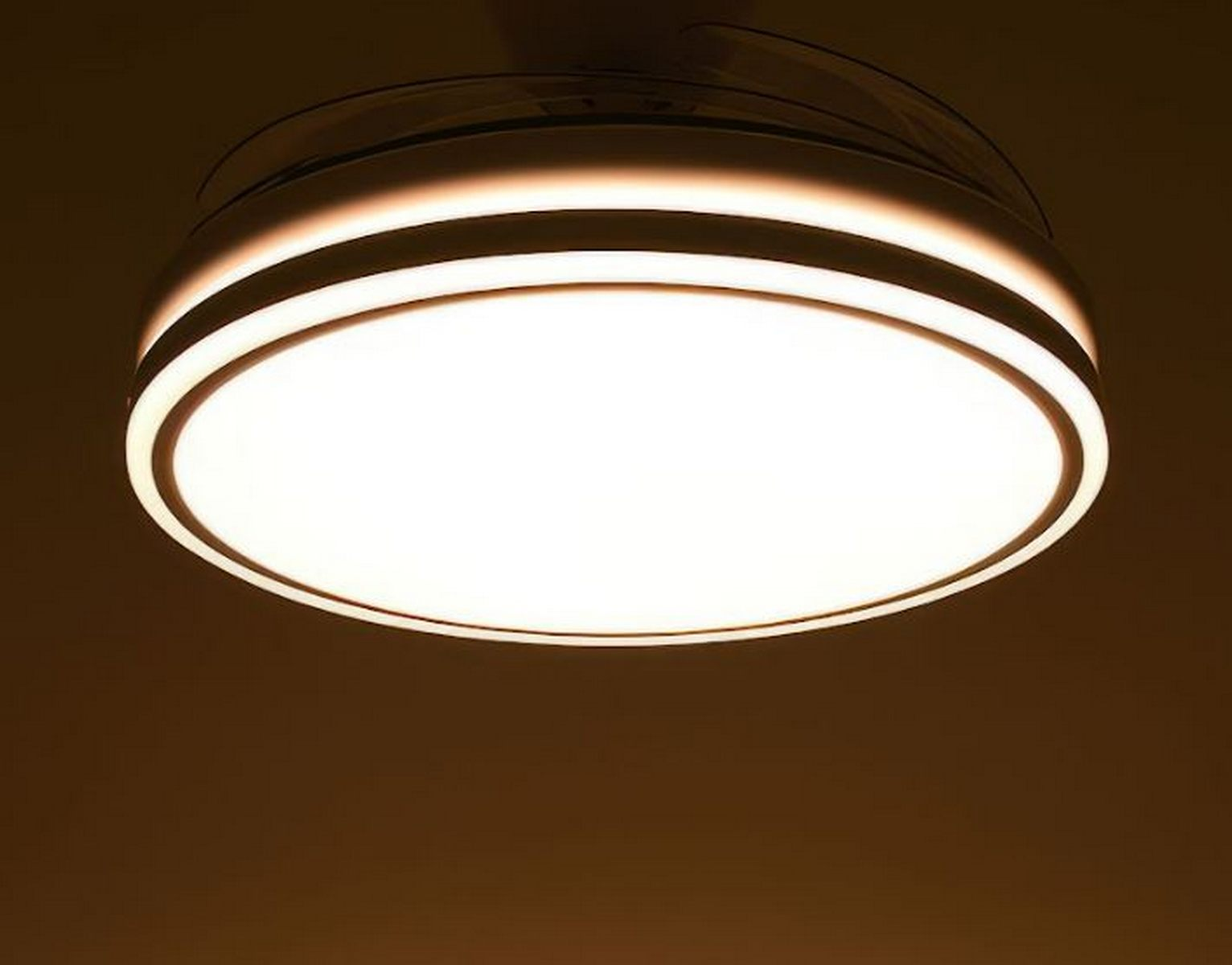 Luz de techo, redonda, con luz blanca y techo marrón oscuro.