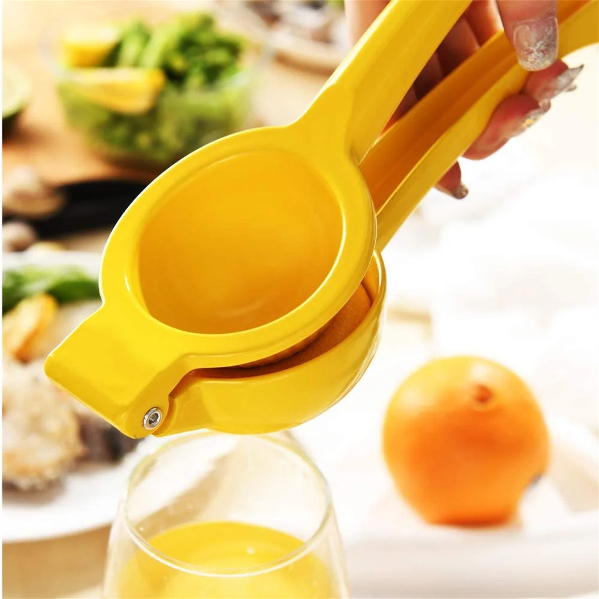 Gelbe Zitronenpresse mit Zitronensaft im Glas und Zitrone.