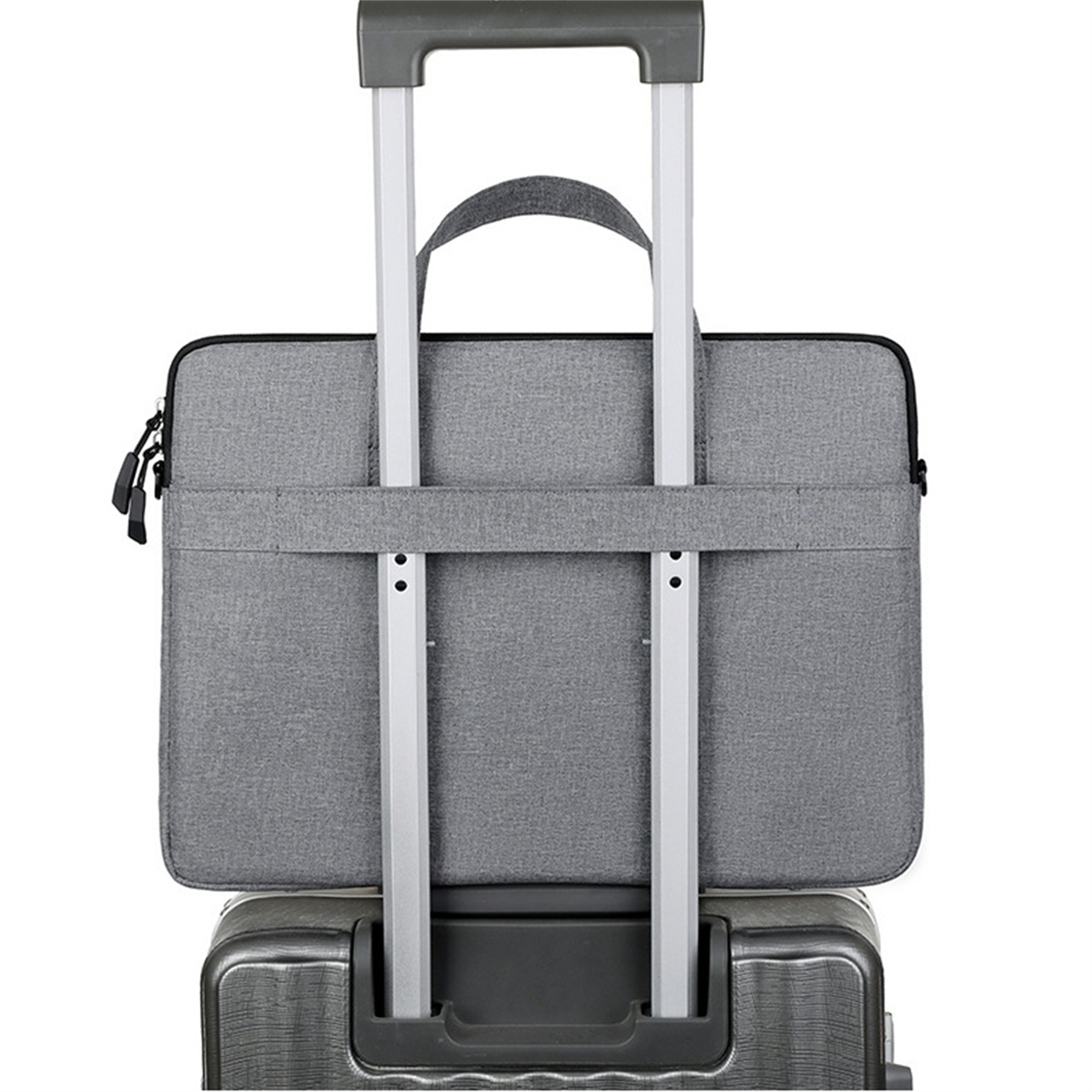 Graue Laptoptasche auf einem Koffer. Der Griff des Koffers ist sichtbar.