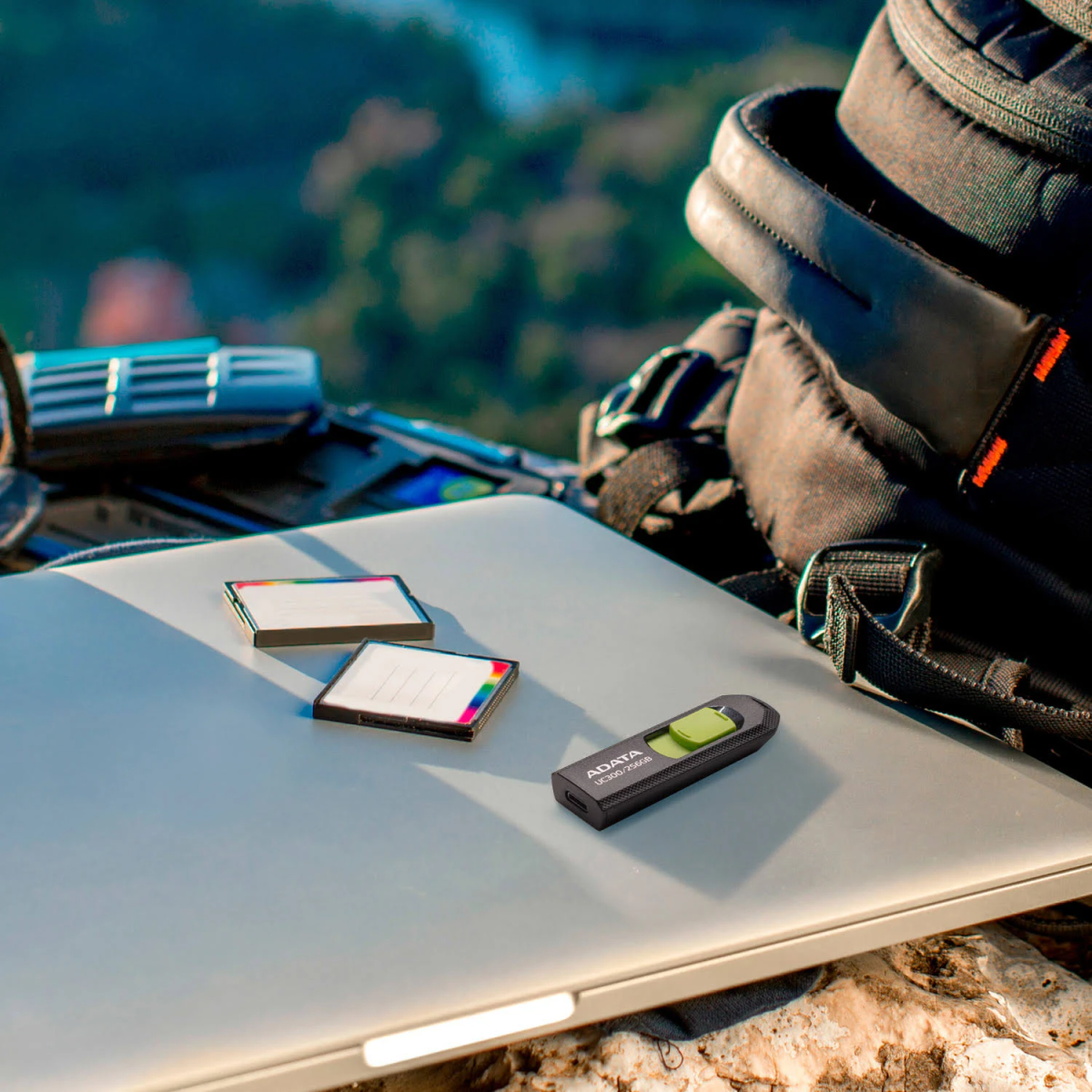 Ordinateur portable, cartes SD et clé USB sur un rocher. Fond naturel. Clé USB verte.