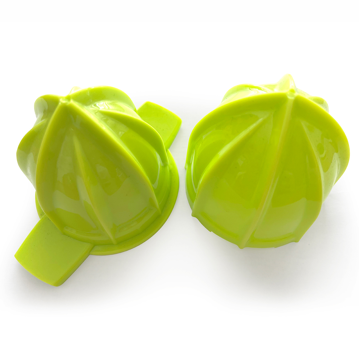 Dos exprimidores de cítricos verdes sobre una superficie blanca. Diseño en forma de hoja.