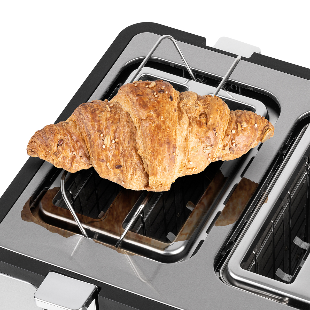 Croissant in einem Toaster. Der Toaster ist silber und schwarz. Das Croissant ist goldbraun.