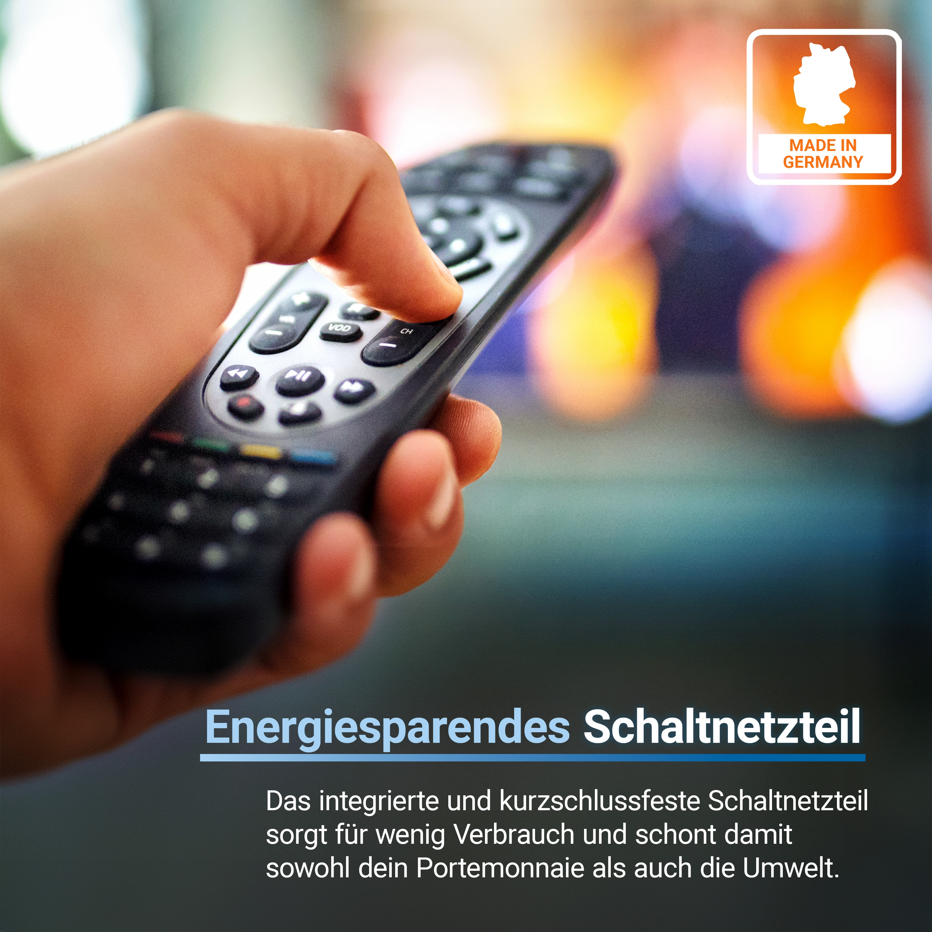 Hand benutzt eine schwarze Fernbedienung. Text: 'Energiesparendes Schaltnetzteil' und 'Made in Germany'.