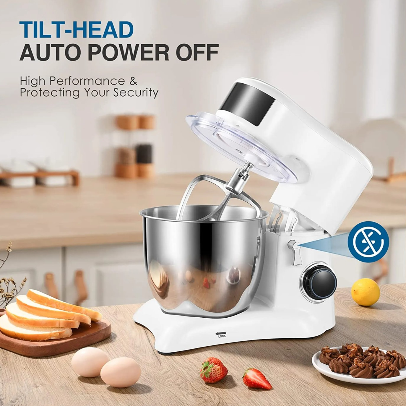 Ein weißer Küchenmixer mit Edelstahlschüssel und Zutaten auf einem Holztisch. Eine Zitrone ist auch sichtbar.