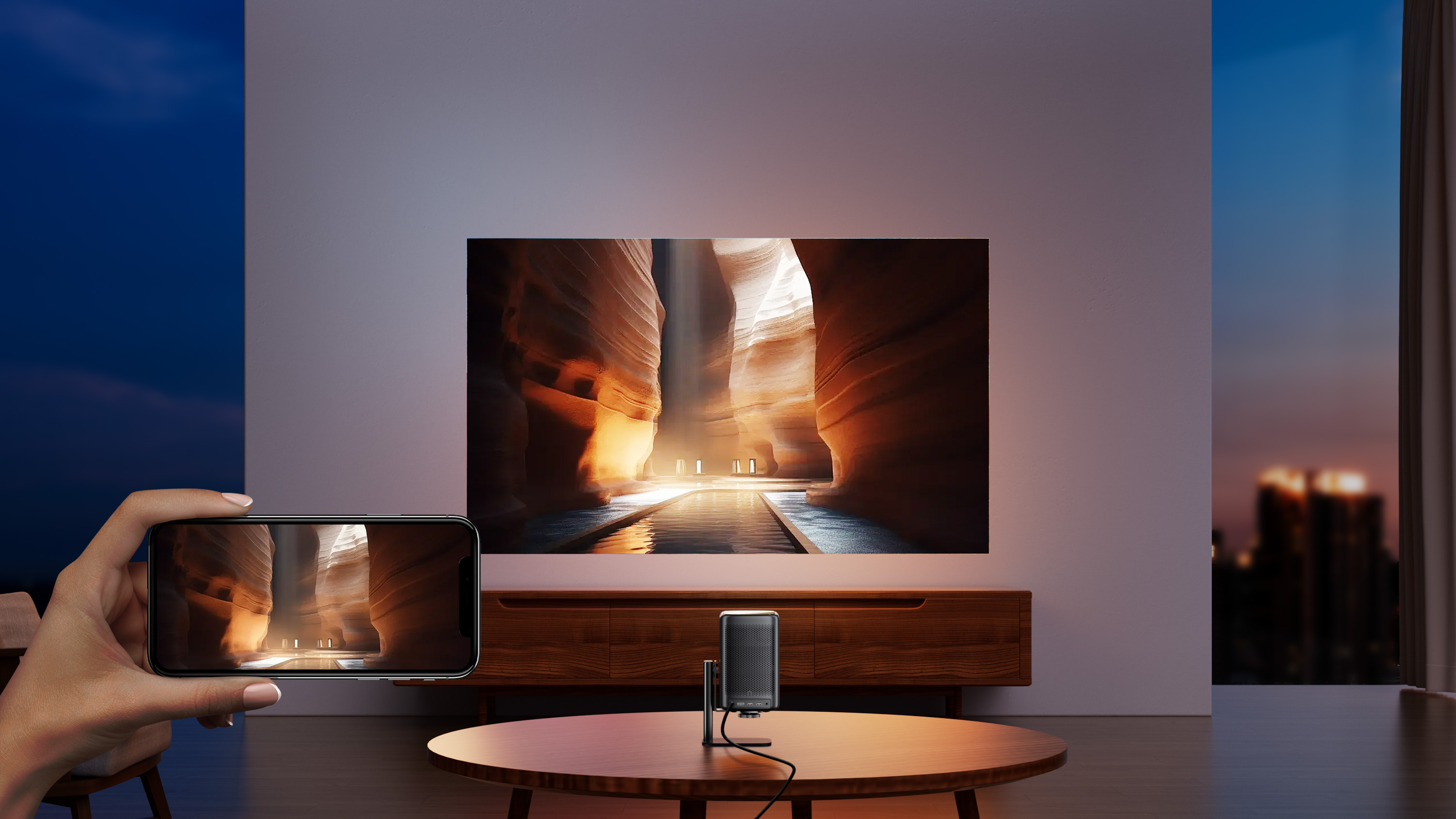 Duży telewizor wyświetlający scenę kanionu. Osoba trzyma telefon pokazujący ten sam obraz.
