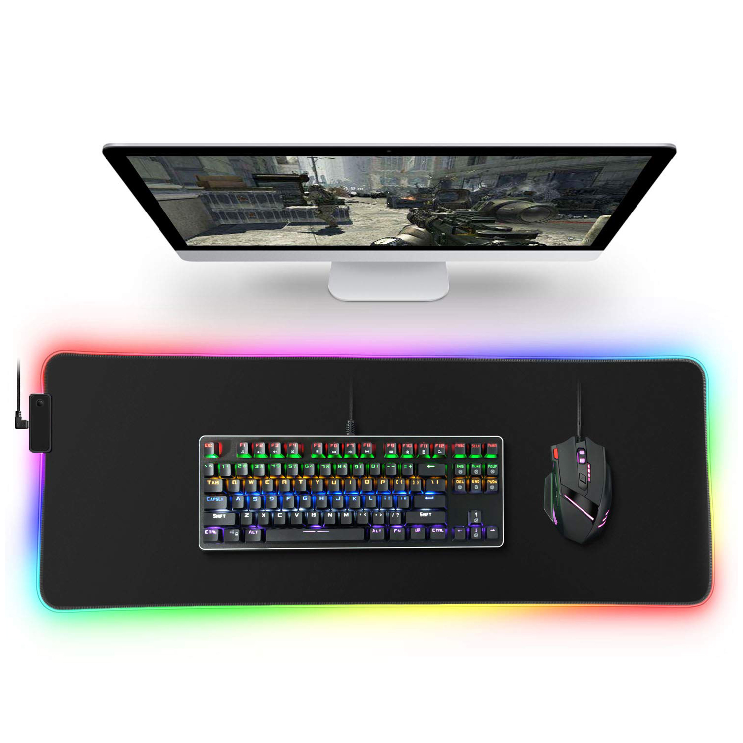 Configuración gaming con teclado, ratón y monitor, con iluminación RGB.