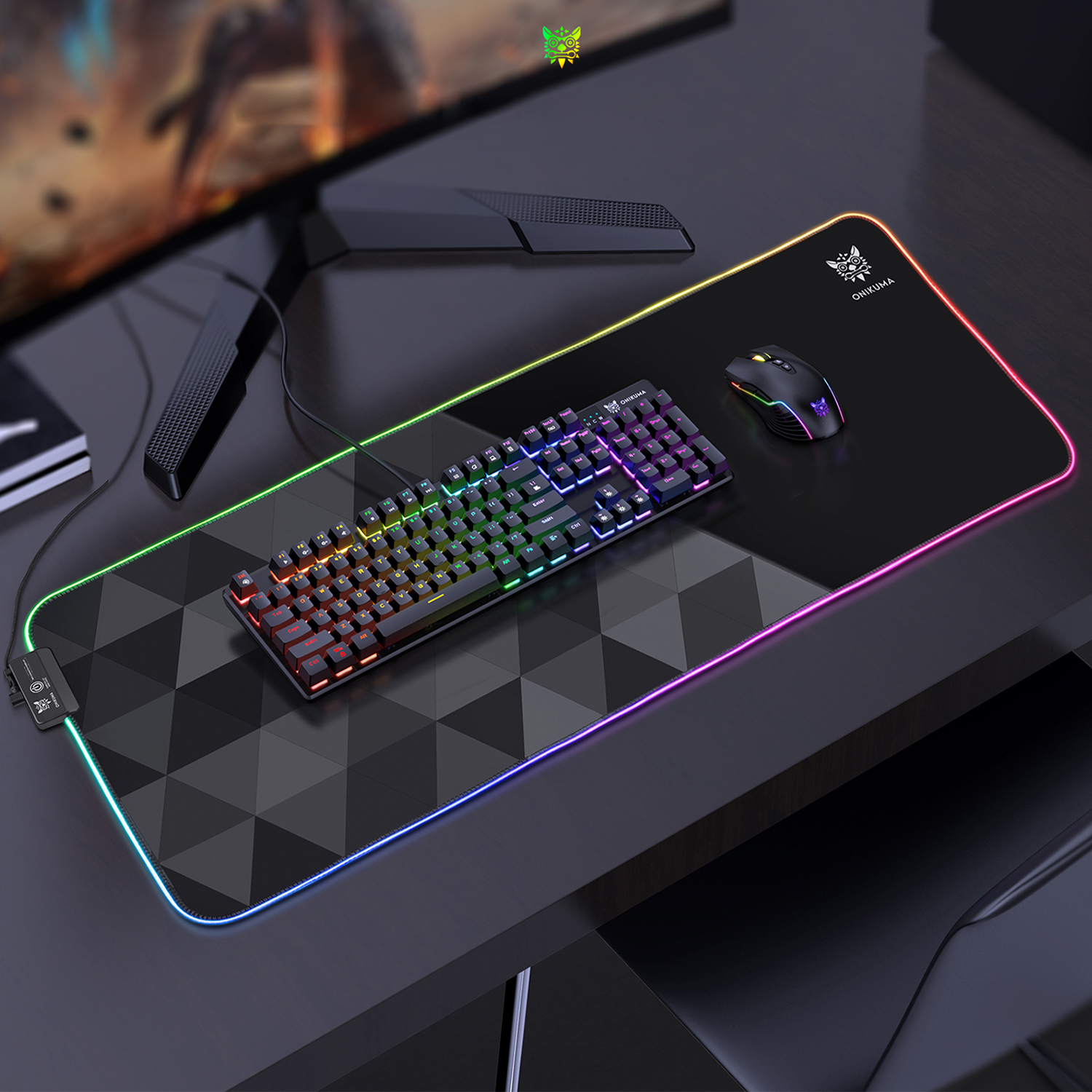 Configuración de juego con teclado, ratón en una alfombrilla grande y monitor de ordenador al fondo.