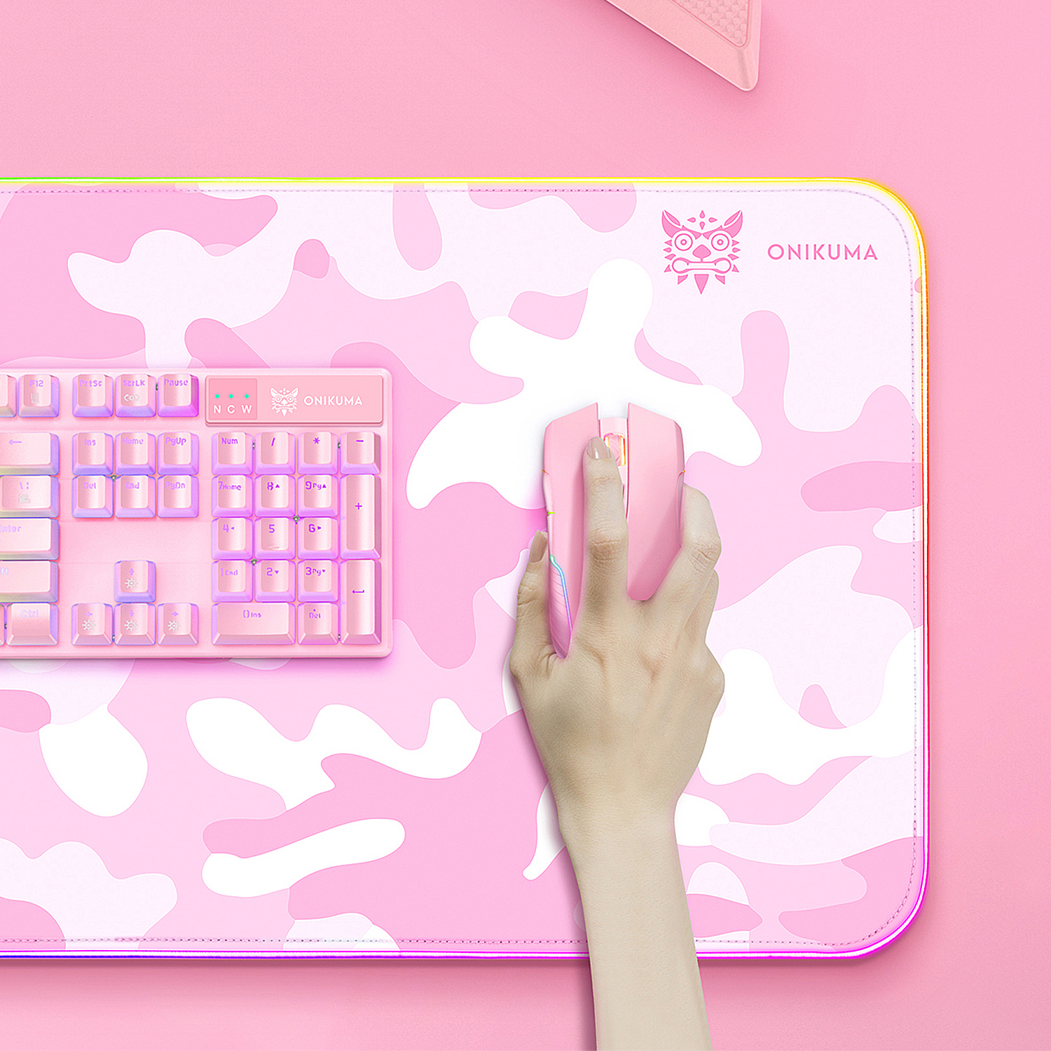 Una configuración de juego rosa con alfombrilla de camuflaje, teclado y ratón.