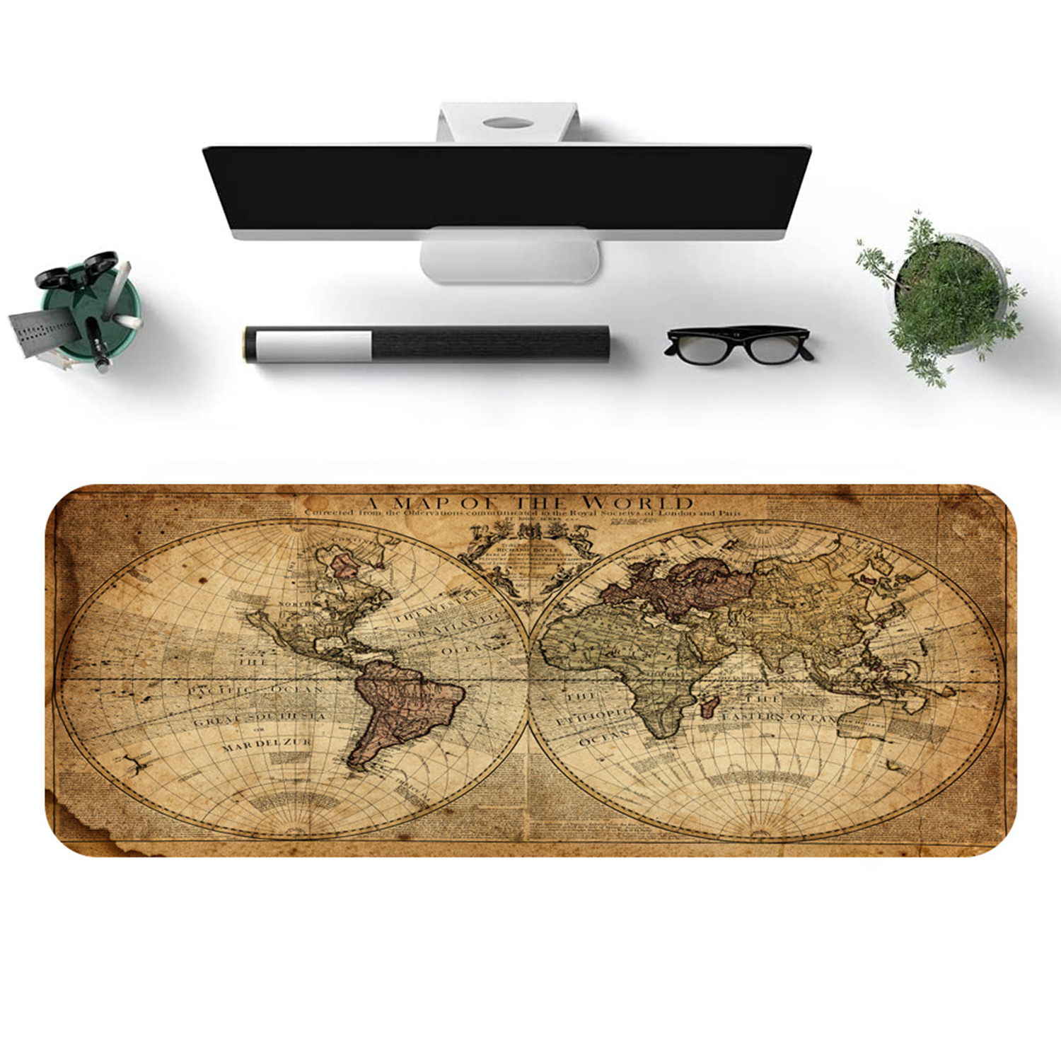 Una configuración de escritorio con un mousepad de mapa del mundo, un monitor y útiles de oficina. Vista cenital.