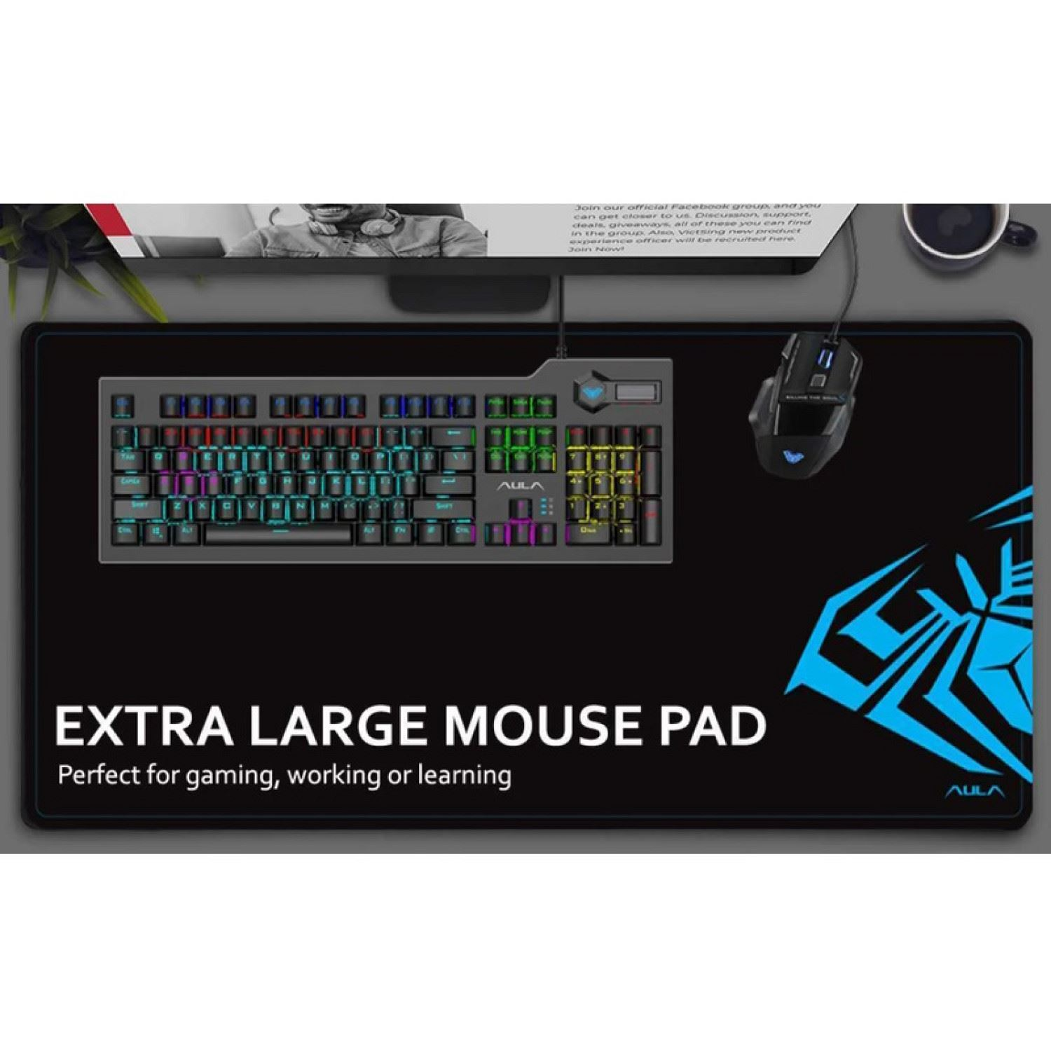 Alfombrilla negra con teclado y ratón. El texto dice "EXTRA LARGE MOUSE PAD". Monitor negro en el fondo.