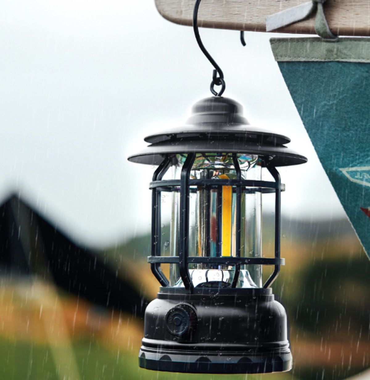 Schwarze Laterne hängt im Regen, mit verschwommenem Hintergrund.