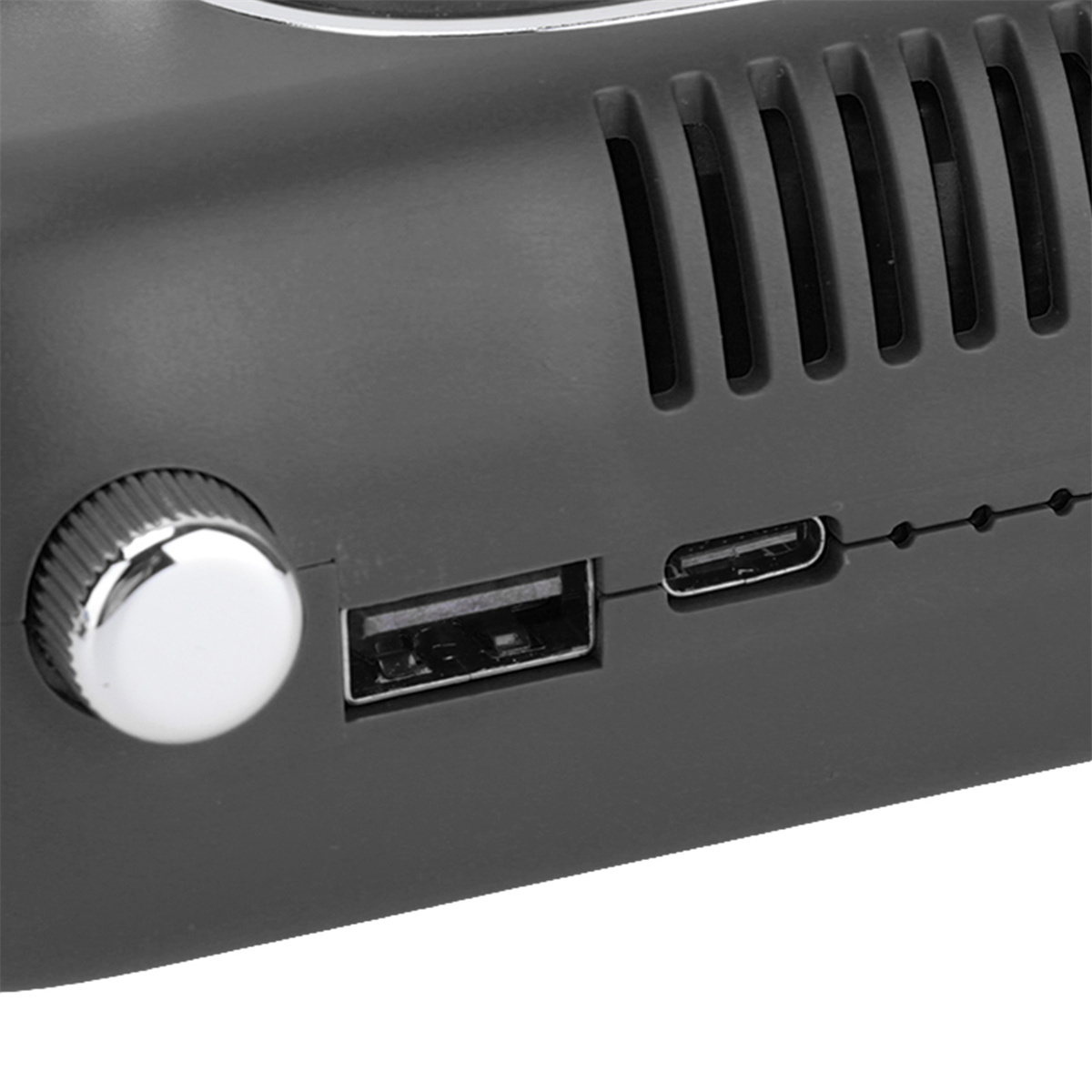 Nahaufnahme eines schwarzen Geräts mit Knopf, USB- und USB-C-Anschlüssen.