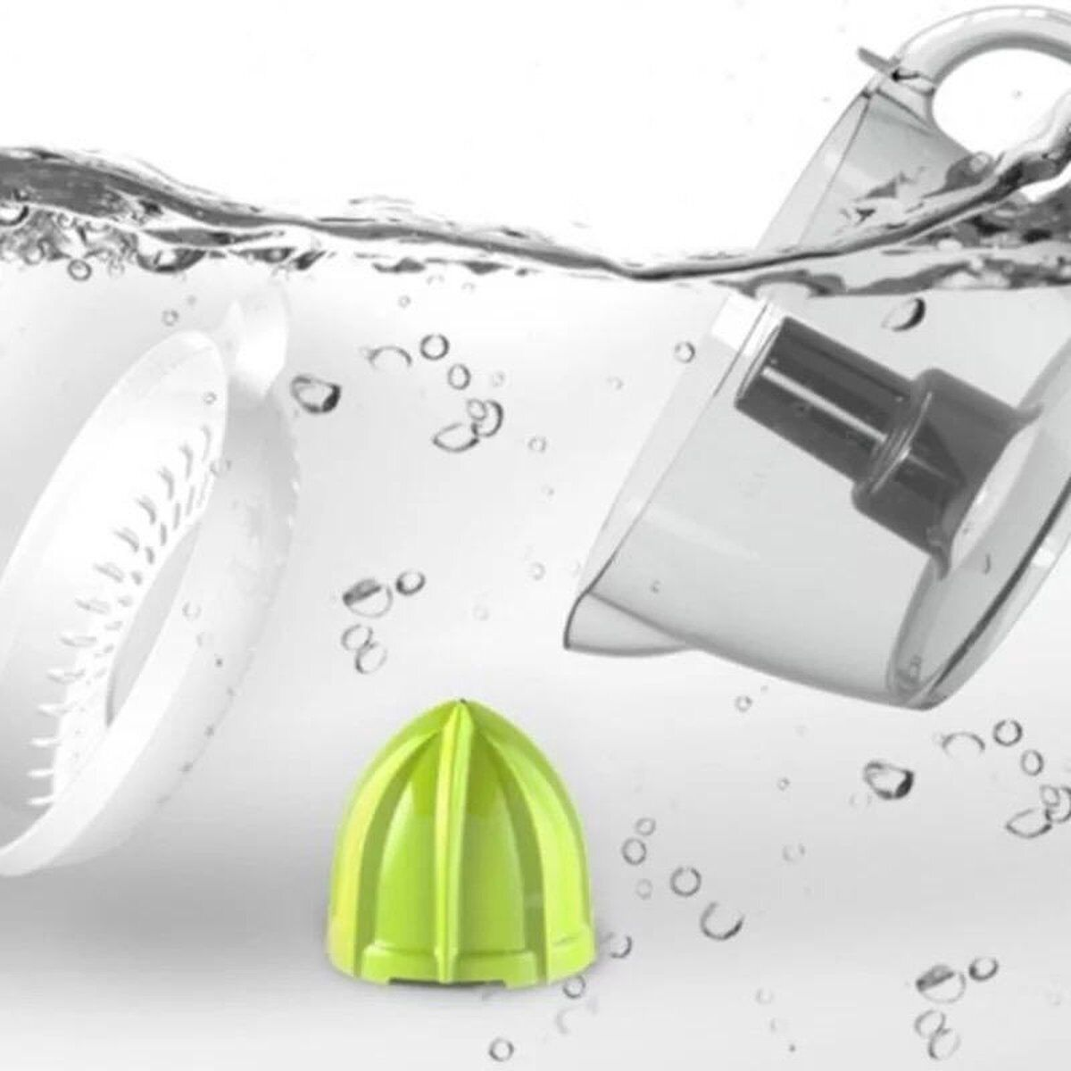 Entsafterteile in Wasser. Ein limettengrüner Entsafterkegel liegt unten, und ein durchsichtiger Behälter.